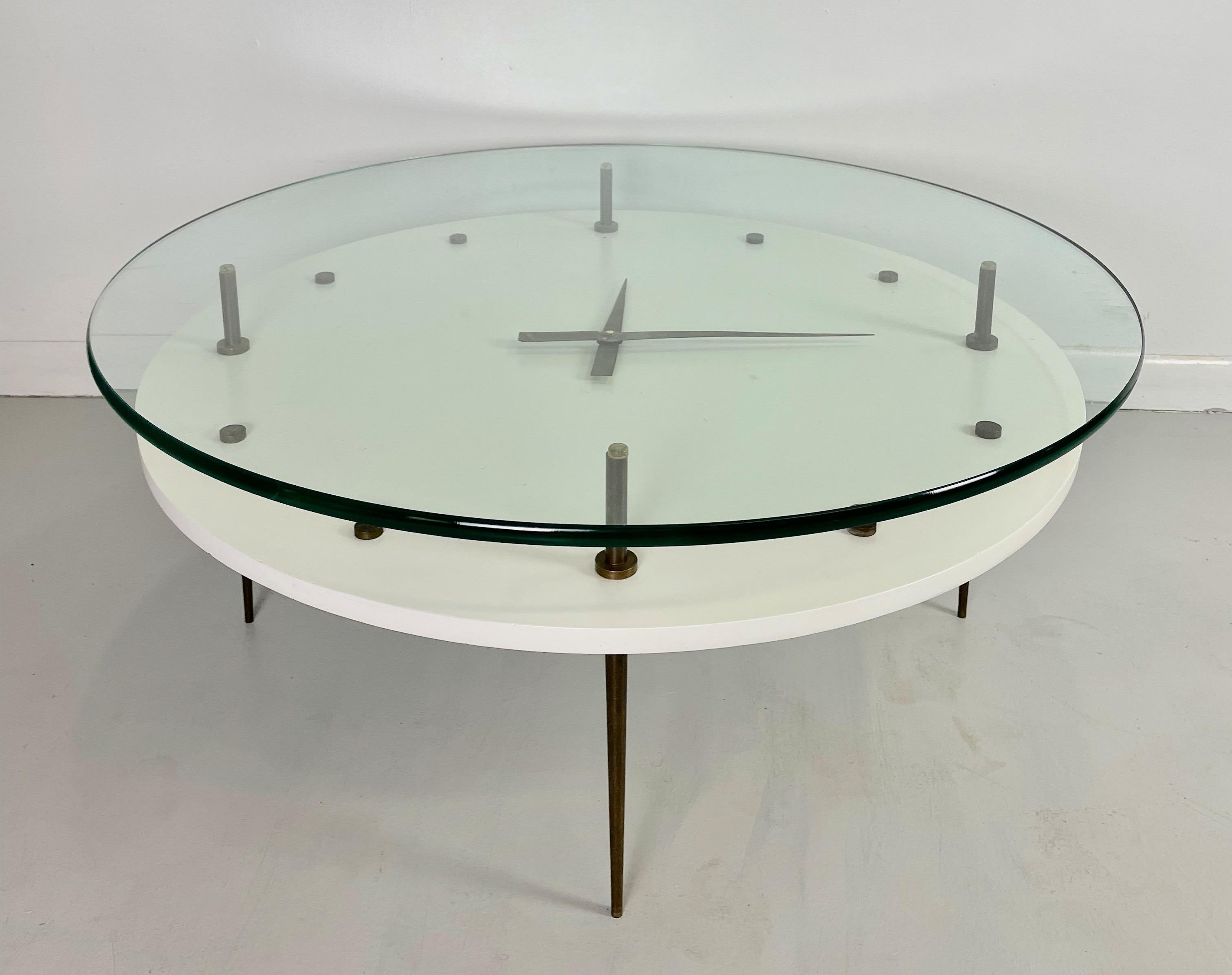 Italian coffee table comprised of lacquer table with solid brass fittings and slender tapered legs. Measures: The glass top is 32