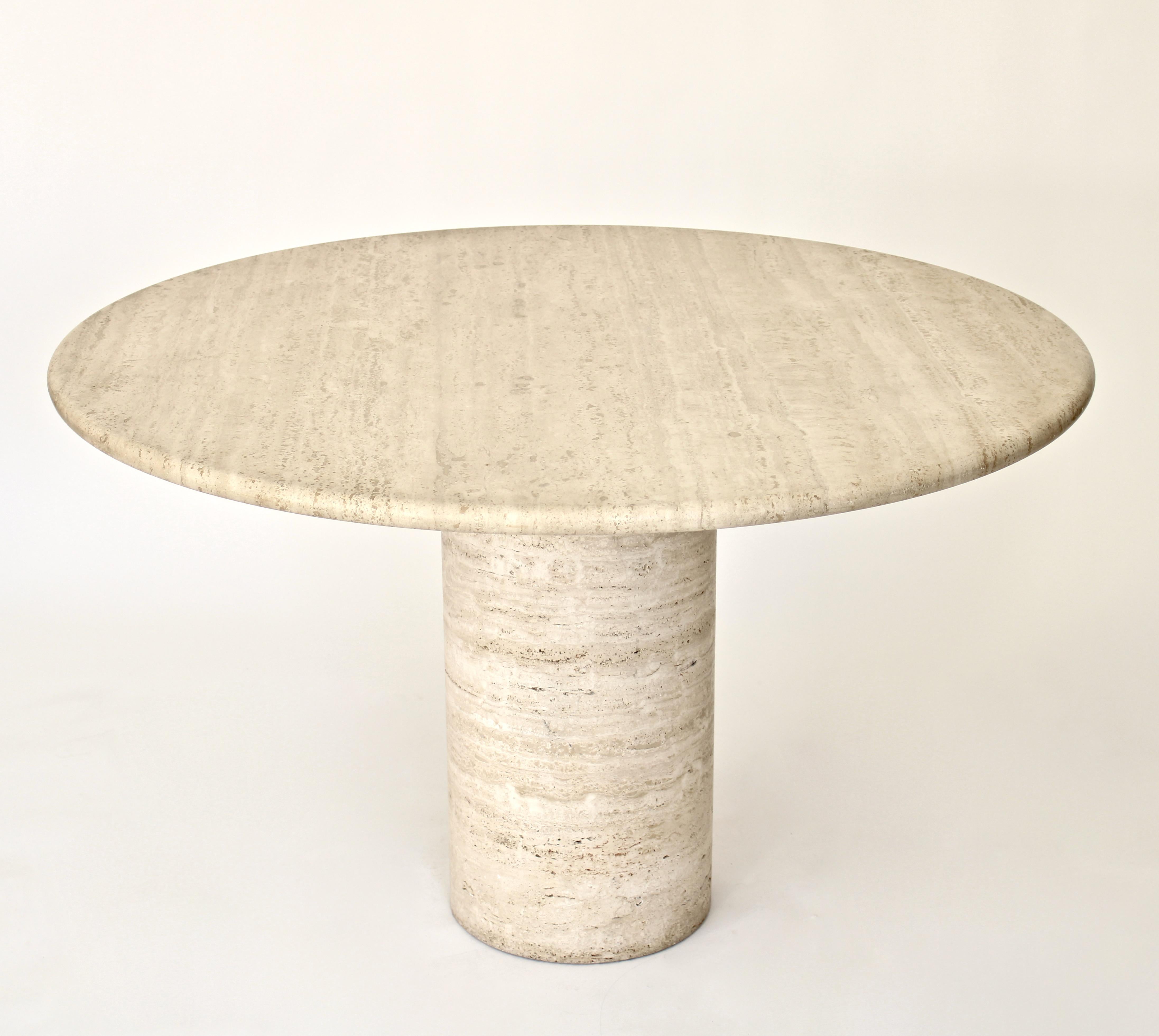 Italian round top cream travertine dining or center table on a round column base.
Variegated tones of cream and beige travertine marble, Italy, circa 1970. The top is honed and not shiny. 
There are no chips or cracks or restorations. 
Overall size:
