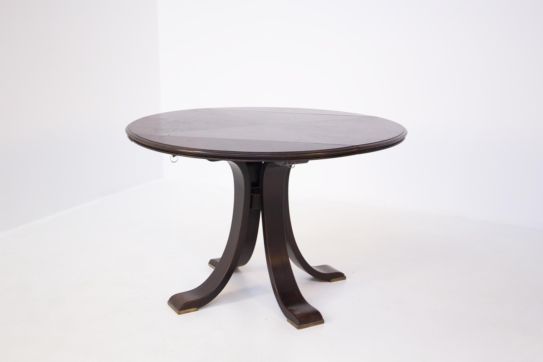 Round table from the 1950s, attributed to Osvaldo Borsani.
The table is foldable in its side parts.
In fact we find under the table top two locks or brass mechanism that allow the two sides to close, thus forming a wall console or as a space saver.