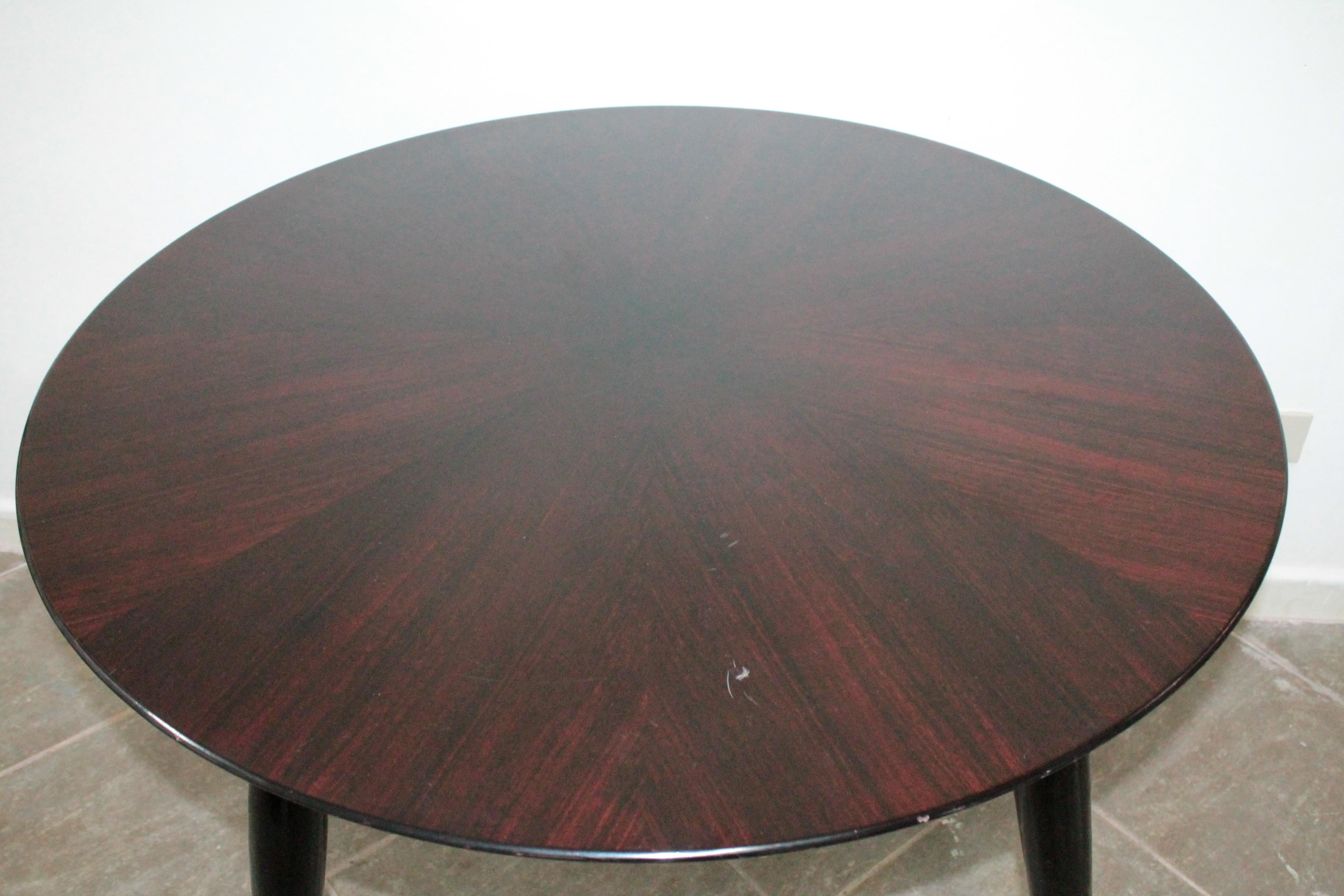 Beautiful Italian round rosewood dining table with feet with brass tips, shows normal signs of use.
It also fits well as a game table.