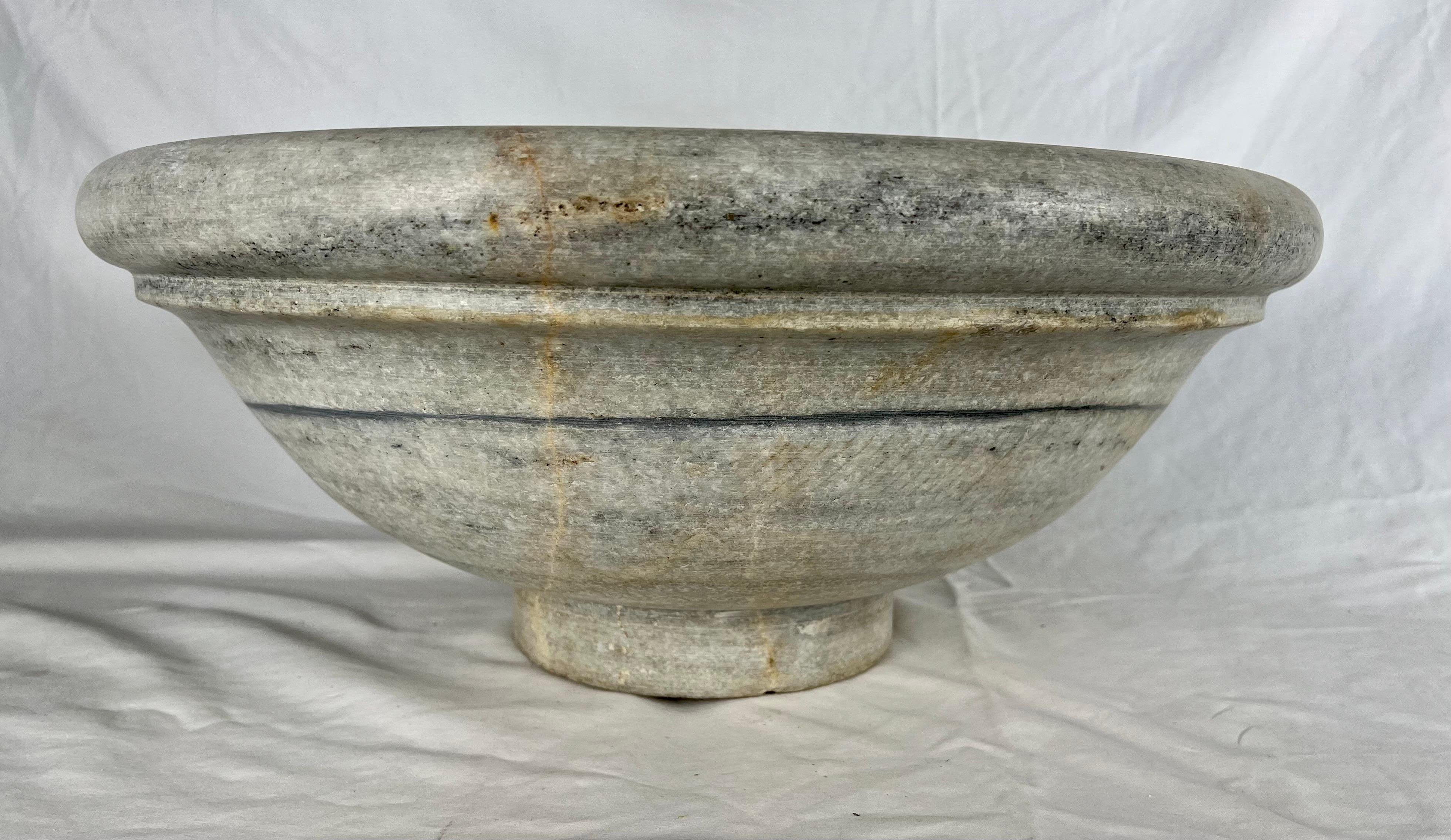 Italian early 20th century round shaped carved limestone sink with drain hole.