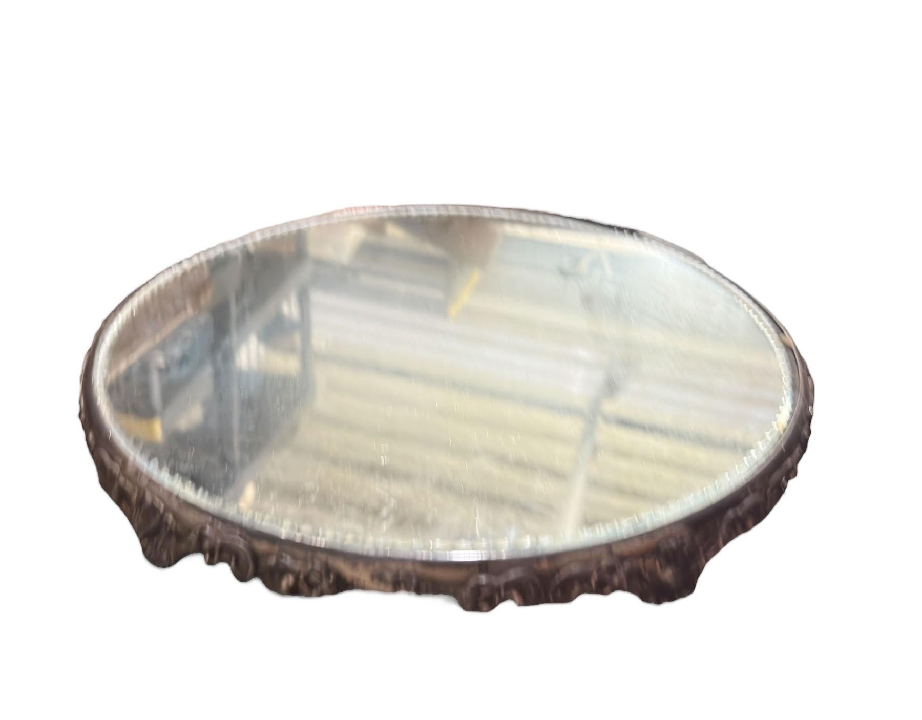 An elegant mid century Italian mirrored plateau featuring a detailed decorative edge and raised feet. The mirrored surface is accented with a delicate scalloped edge mirror, adding subtle sparkle and dimension. Likely quadruple silver plated, this