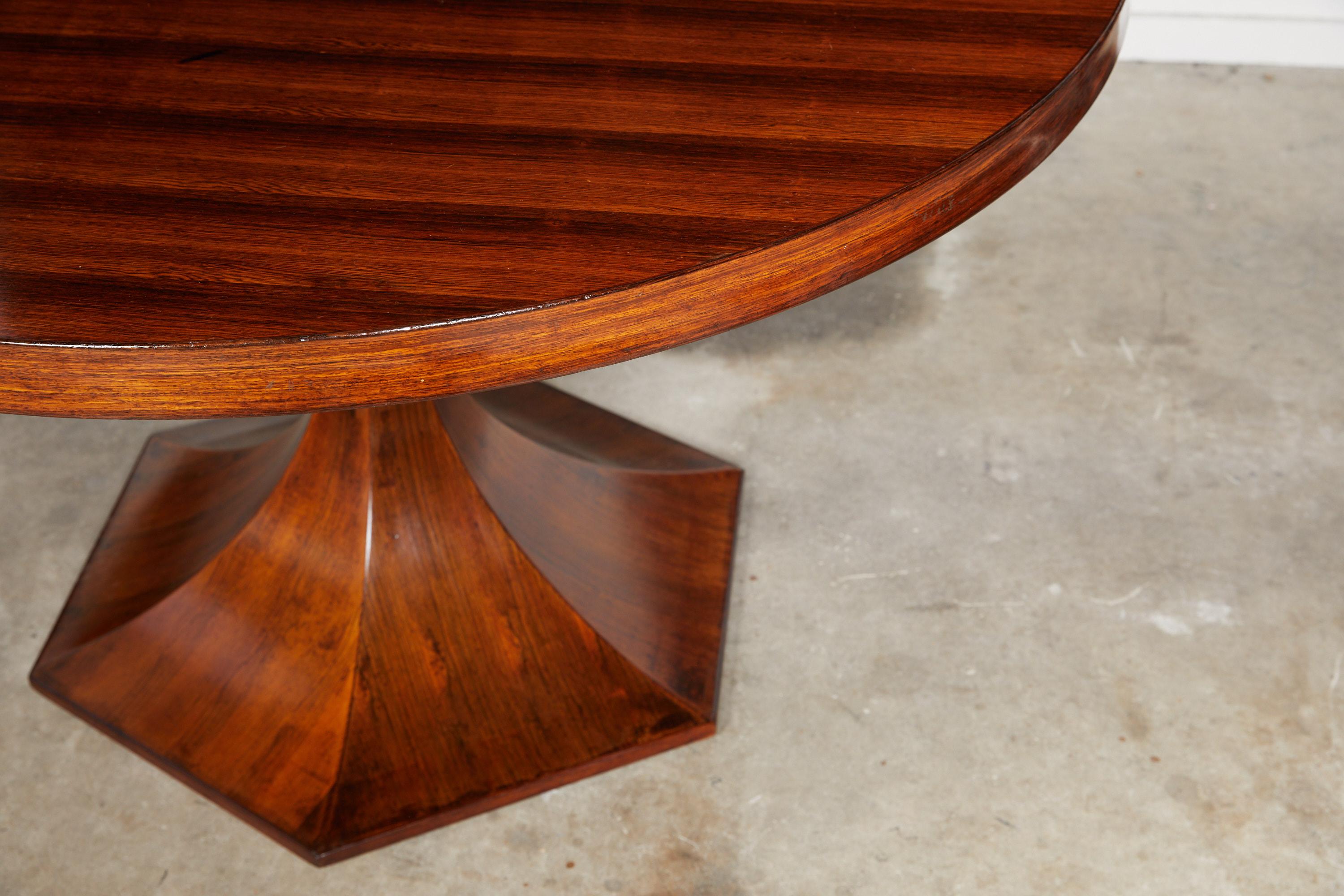 20th century Italian dining table of palisander wood with a round tabletop on a hexagonal tulip shaped pedestal base.