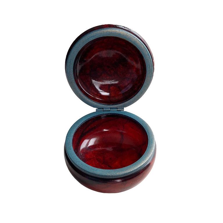 A small round red Italian opaline trinket box. In a rich deep ruby red, this vintage box will be glamourous on a dresser, nightstand, or coffee table. Large enough to hold bobby pins, but we think it would be a fantastic place to hide pills. Its