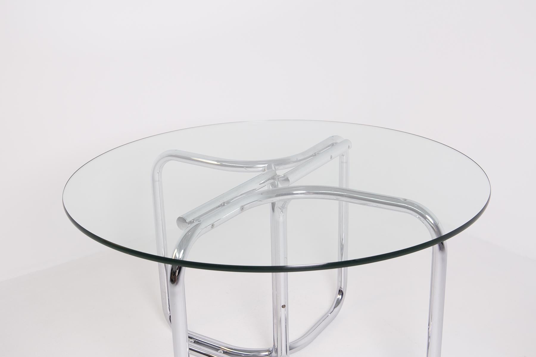 Modern Italian table from the 1970s by Giotto Stoppino in steel and thick glass.
The table has a thick glass top with a round circular shape in original condition.
The particularity of the round table is in its support structure made of tubular