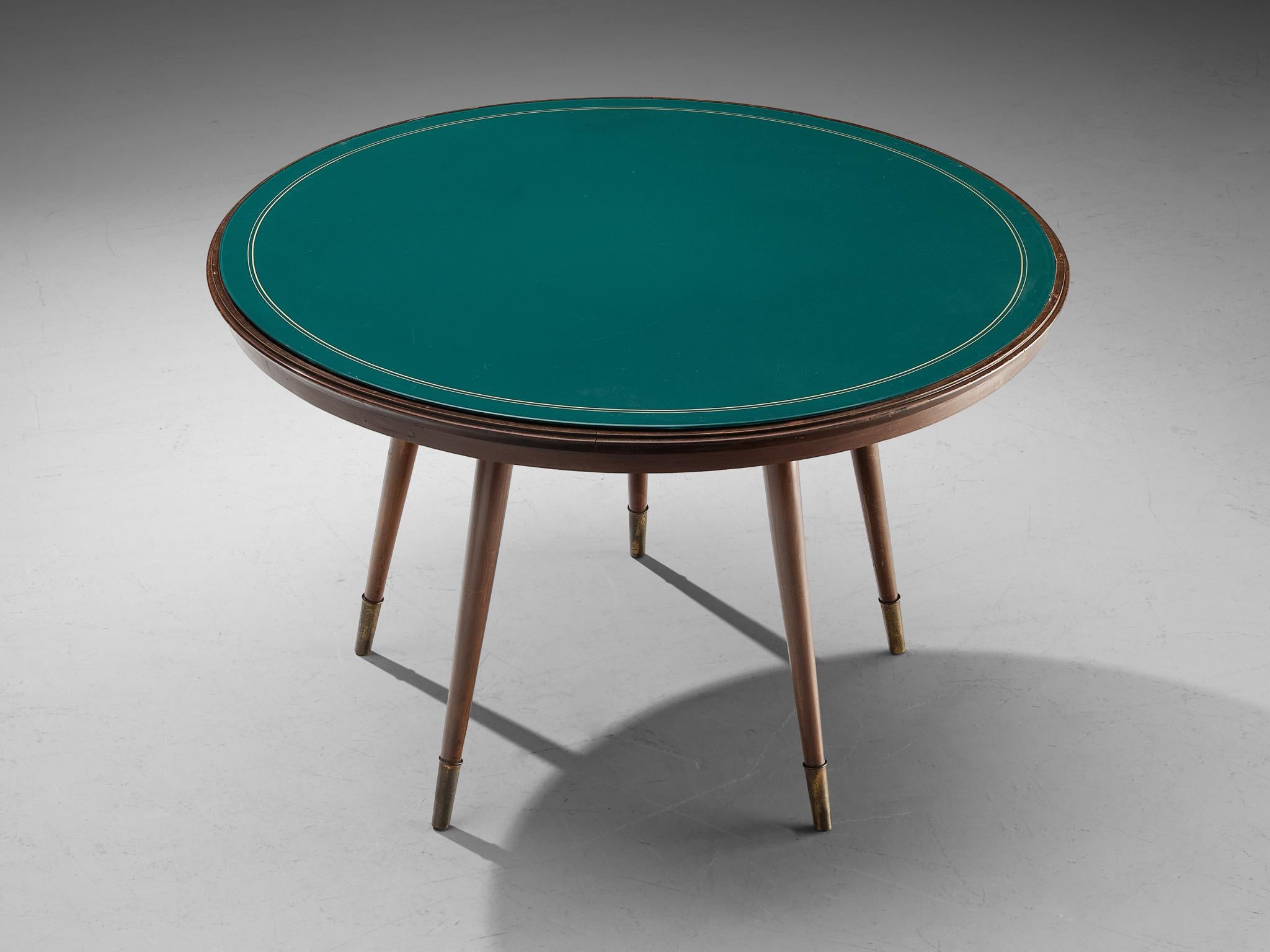 Round centre or dining table, wood, glass, Italy, 1950s

Elegant round dining or center table made in Italy in the 1950s. The table top is executed in green glass with circular white detailing around it. The top is resting on five legs with brass