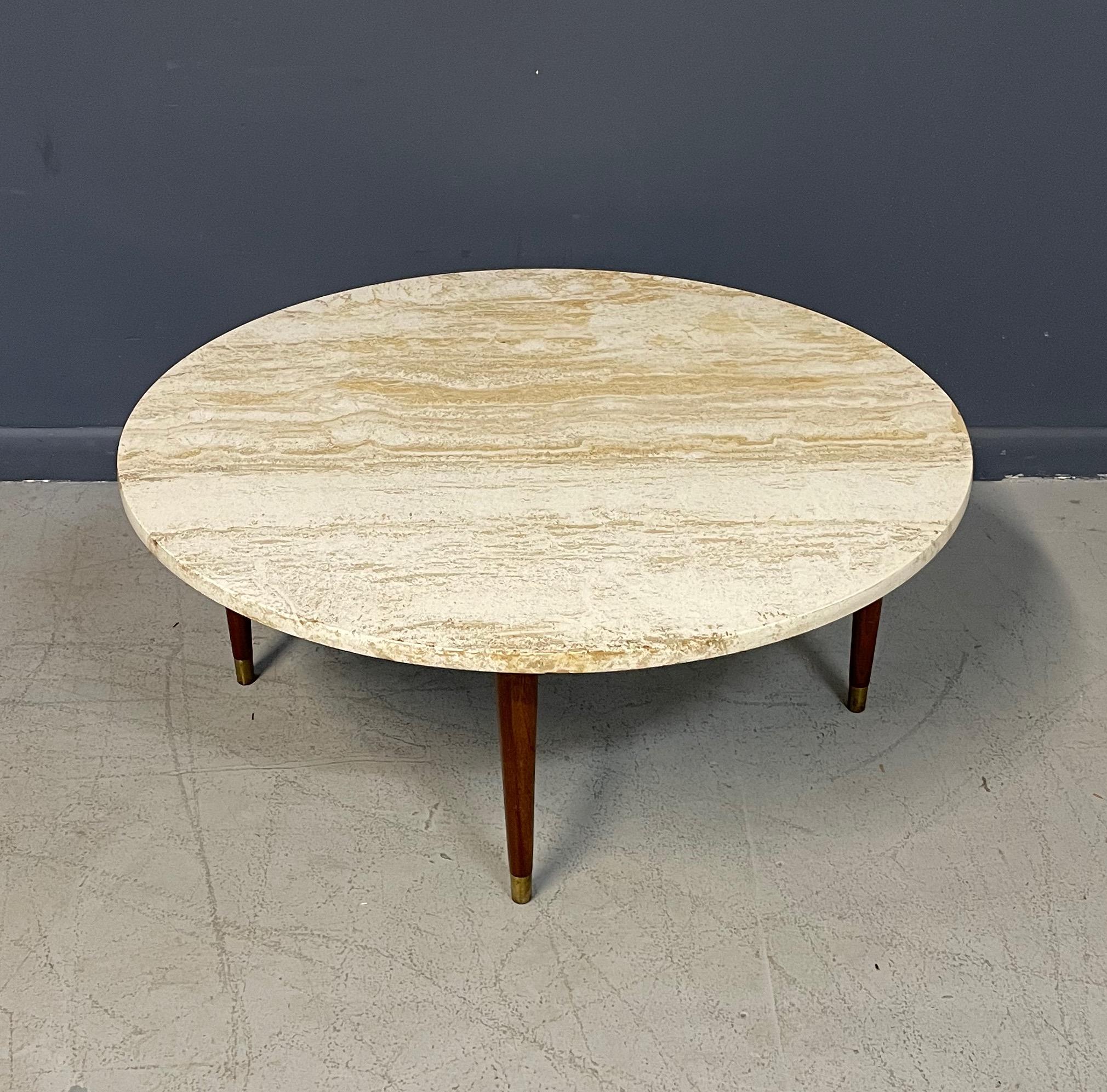 Travertine coffee table with walnut legs in a very usable size that would work well in numerous settings including a small apartment setting. This piece is classic mid century design pairing stone and would with nice brass accents.