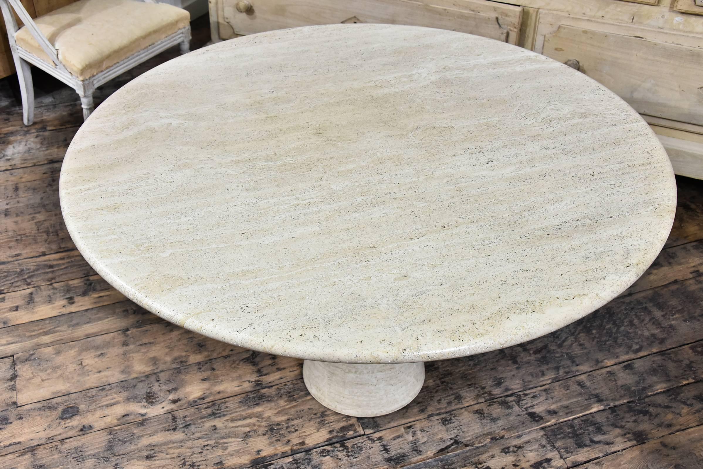 Sophisticated travertine pedestal table in warm cream and beige tones, excellent condition.