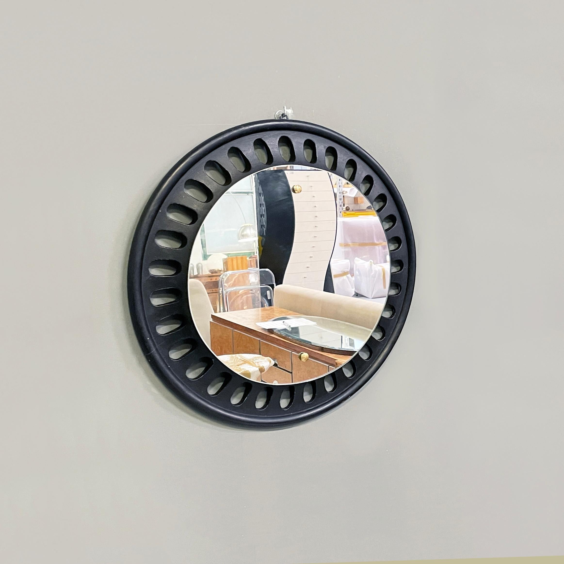 Italian Round wall mirror in black wood, 20th century
Round wall mirror in black painted wood. The frame has oval decorations. Small brass buttons on the mirror. 
20th century.
Good condition, light marks on the wood. The brass is in