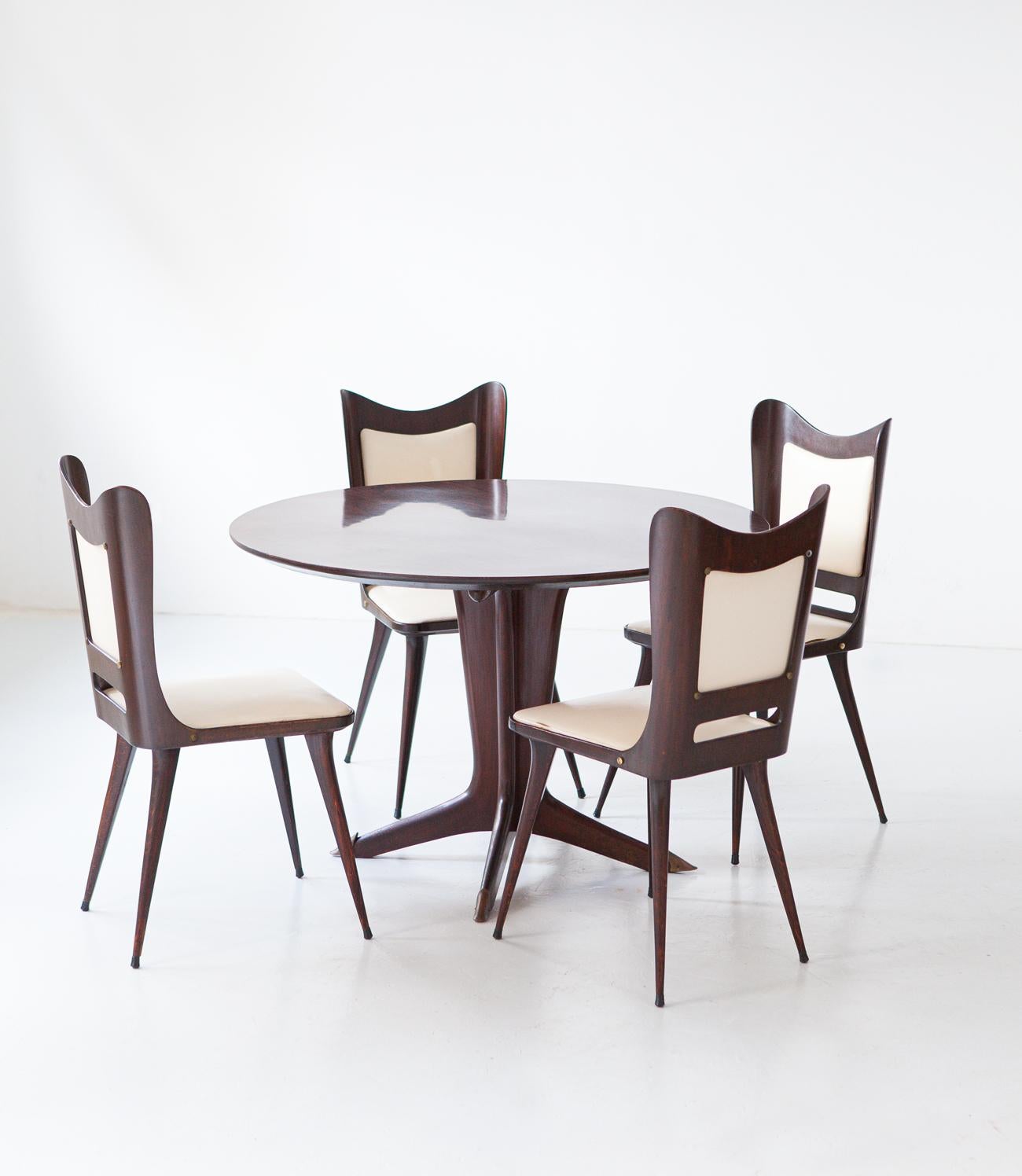 Dining set by Carlo Ratti , table and four chairs, Italy, 1950s.

Table and chairs in dark lacquered exotic wood, with cream-colored fake leather upholstery.
High Italian carpentry, elegant and sculptural modern design.
The original condition is