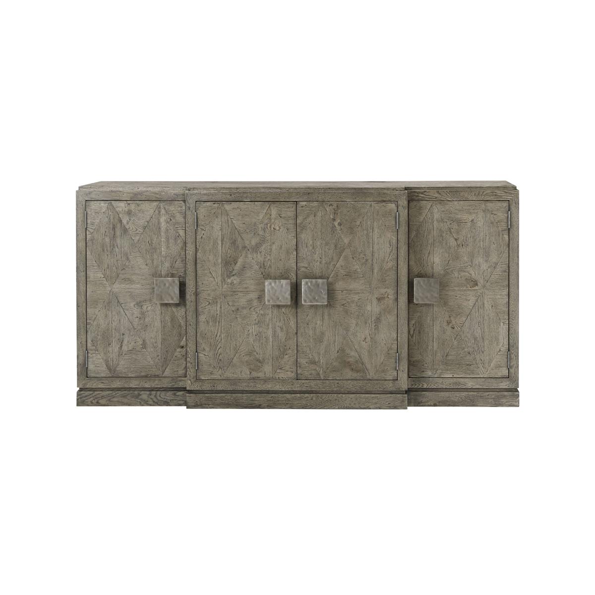 With four doors having bold 'vintage' metal handles with three sections and interiors with adjustable shelves, the center section with a fixed drawer and credenza raised on a plinth base.

Dimensions: 80.5