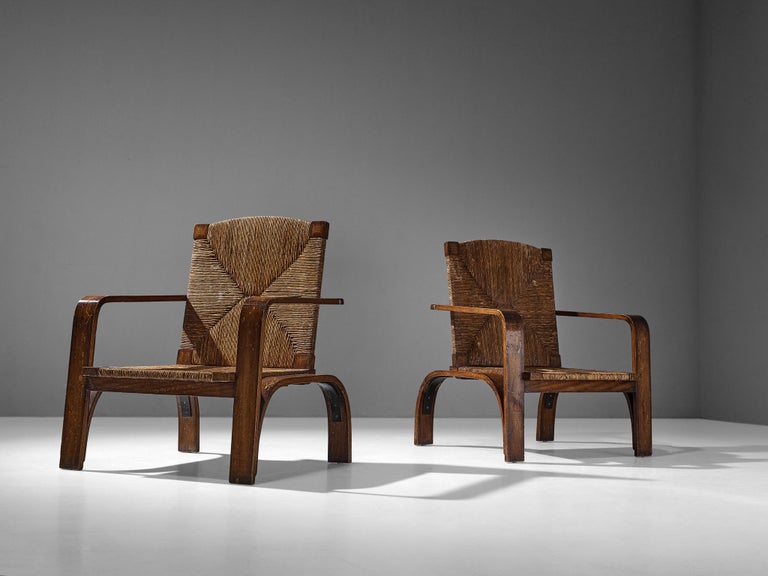Pair of armchairs, straw, stained wood, metal, Italy, 1950s

These largely sized lounge chairs contain an evolved rustic character achieved by the use of materials and the constructive frame. The arch-shaped legs take the unit out of proportion as
