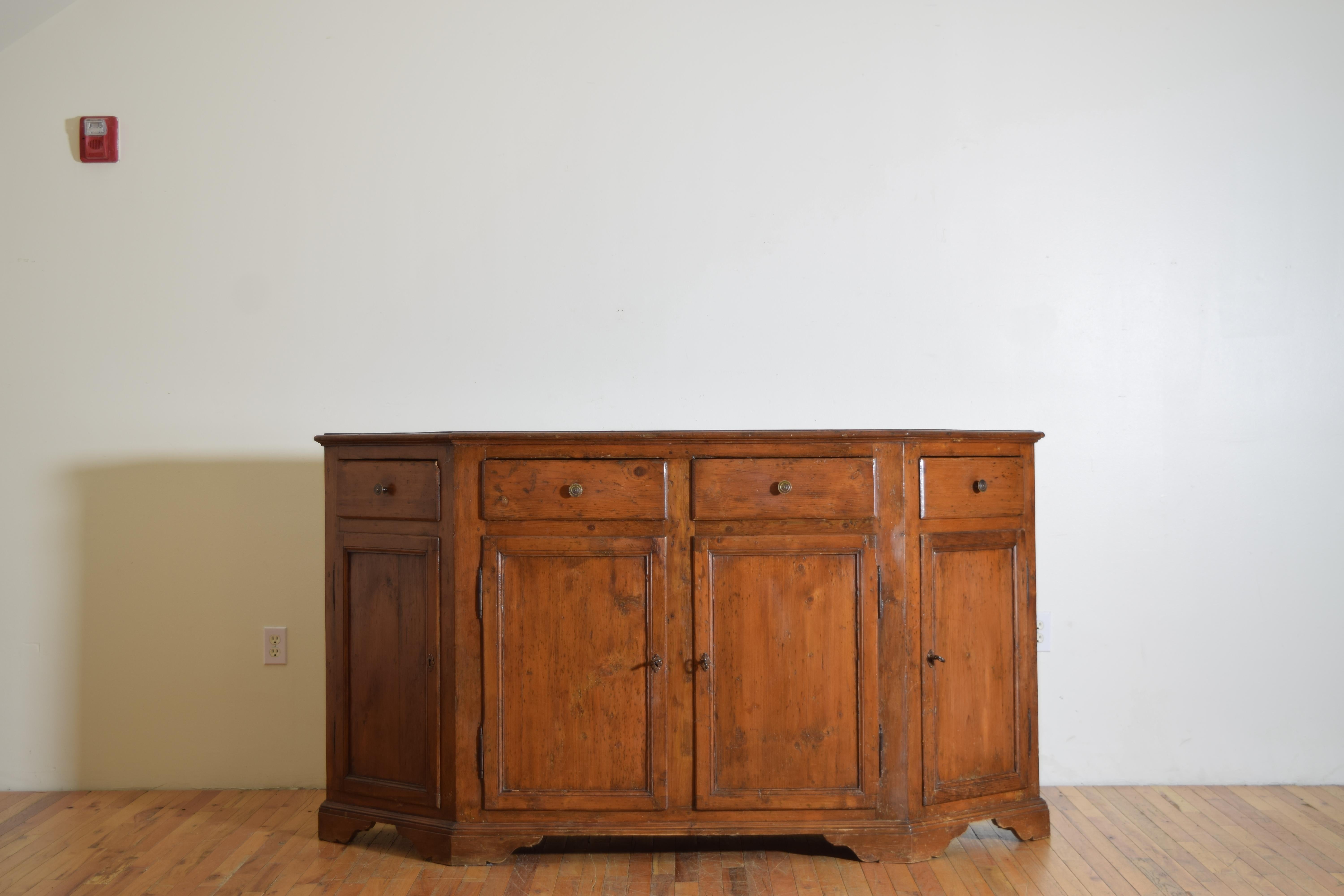 costruito interamente in legno di Larice, un legno di pino montano, ha un piano rettangolare con angoli inclinati (scantonata) con un bordo modellato sopra una cassa conforme che ospita quattro cassetti sopra quattro porte, l'interno con scaffali,