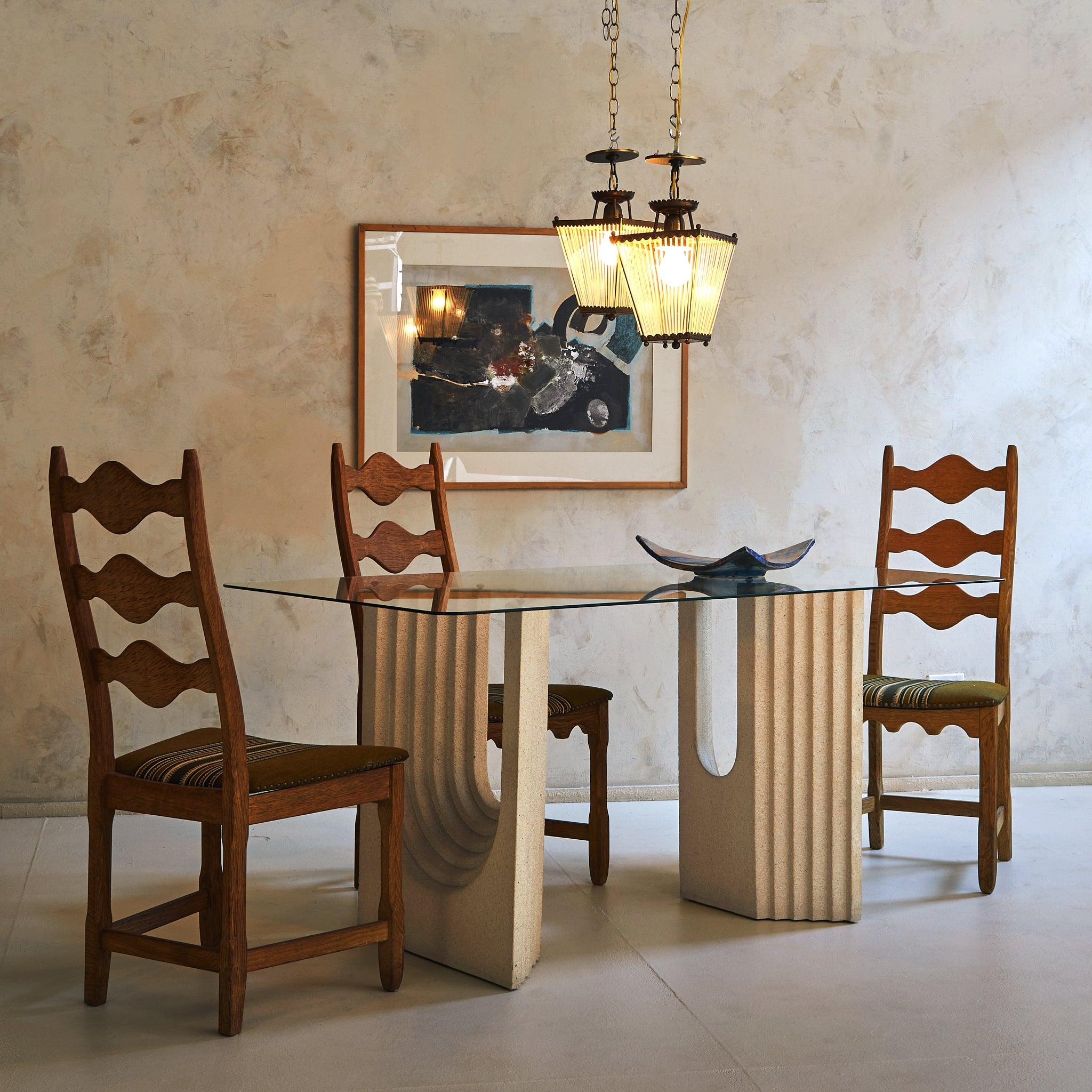 A commanding presence with architectural poise, this 1970s Italian dining table pays homage to Carlo Scarpa’s masterful designs. The sculptural sandstone bases, with deep fluted arches, evoke grandeur while maintaining an organic warmth. A