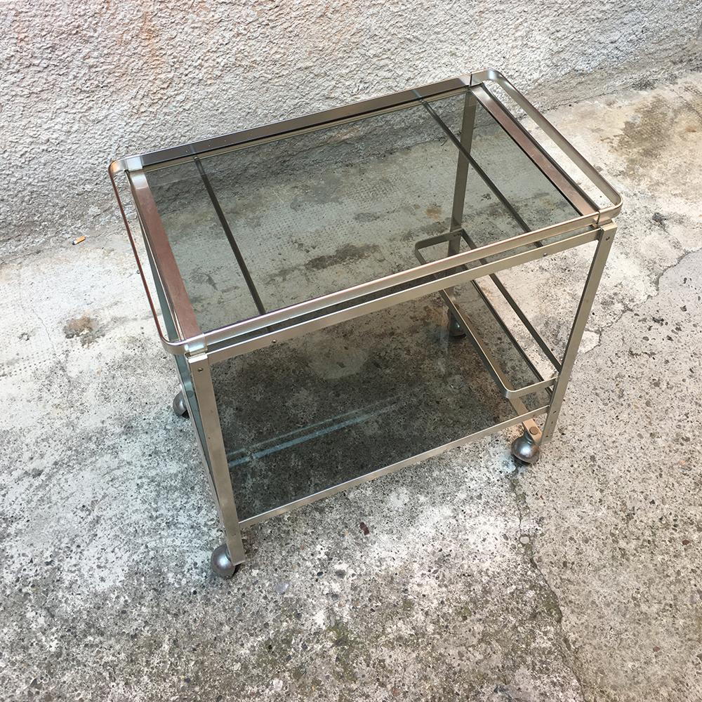 Italian satin steel and smoked glass bar trolley with bottle holder, 1970s
Italian satin steel cart with smoked glass, double shelves and bottle-holder, dating to the 1970s. Structure on wheels, bottle-holder space in the lower part.
Very good