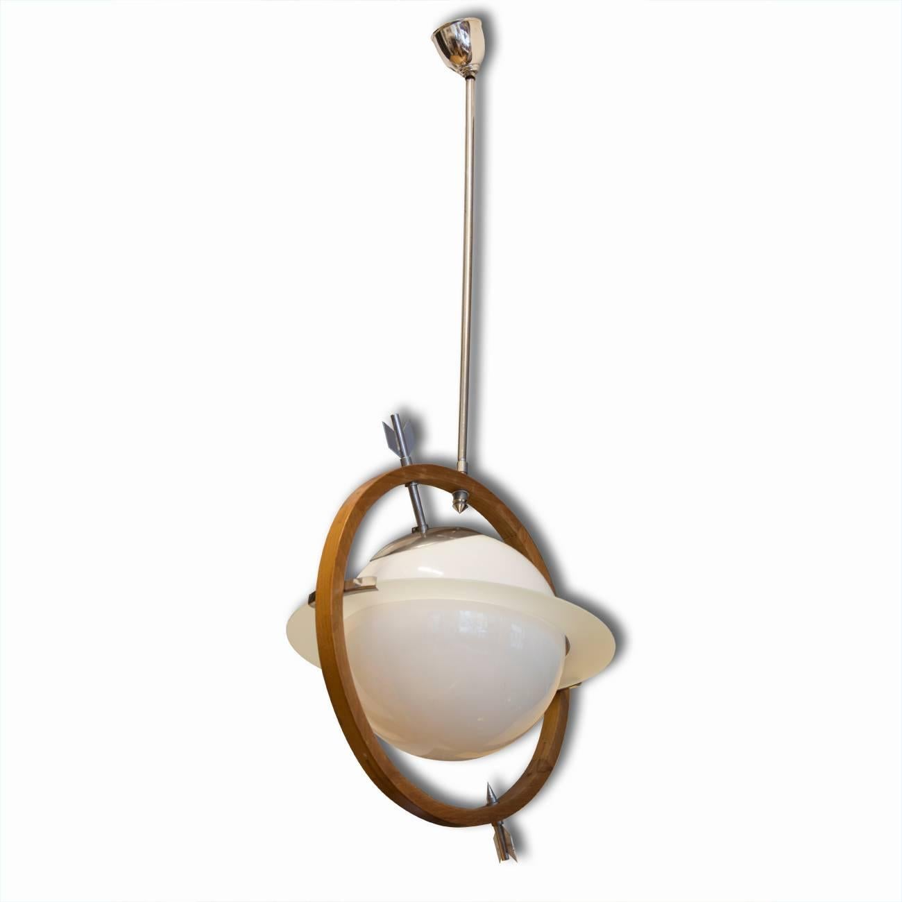This Art Deco 1930s Italian pendant light is in the form of the planet Saturn and was designed by Gio Ponti and Pietro Chiesa. The central glass globe in milky glass is pierced by an arrow floating within a wooden ring suspended from a chrome rod.