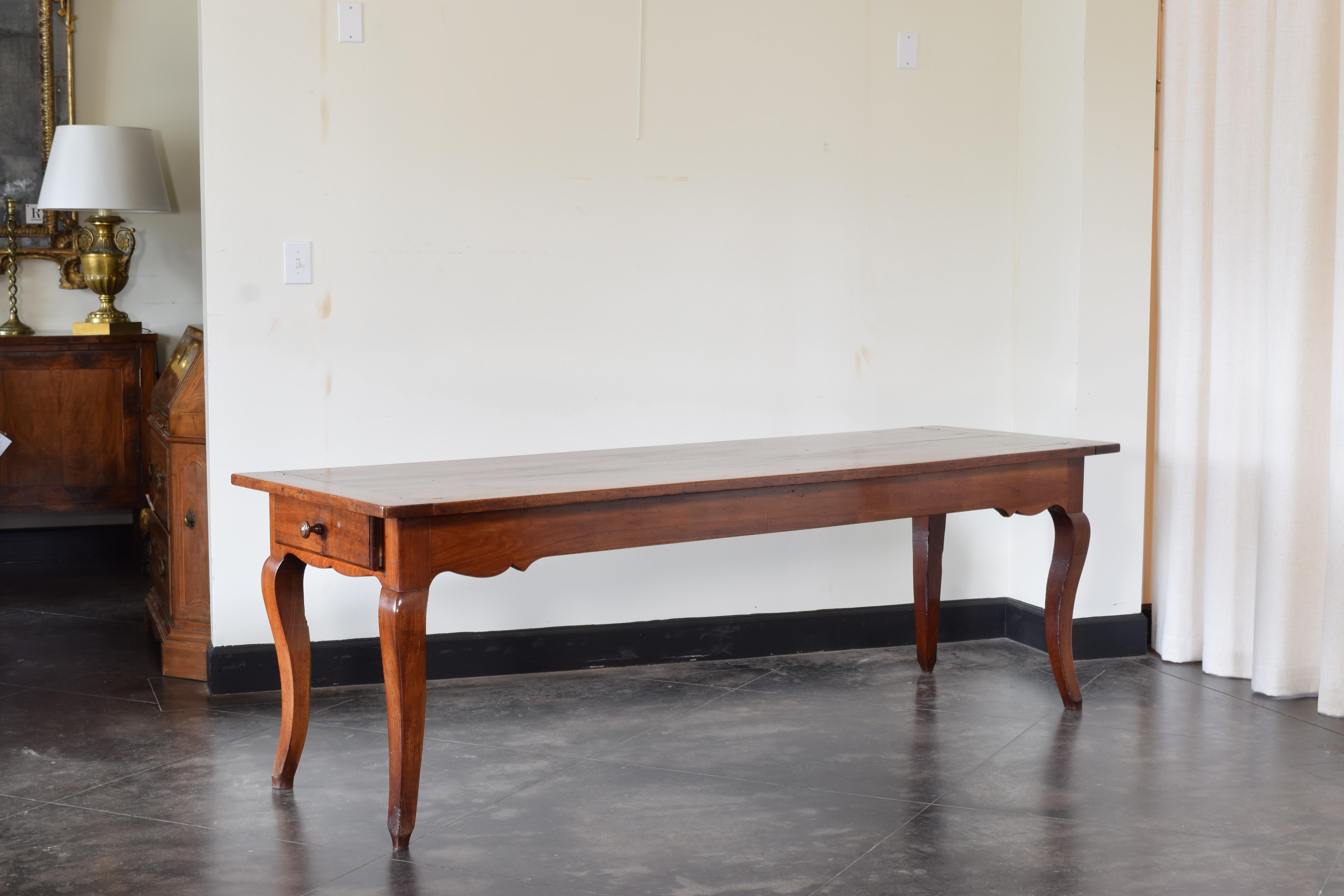 Having a rectangular top with breadboard ends and rounded corners atop a conforming frame housing two side drawers, the apron interestingly shaped, raised on cabriole legs