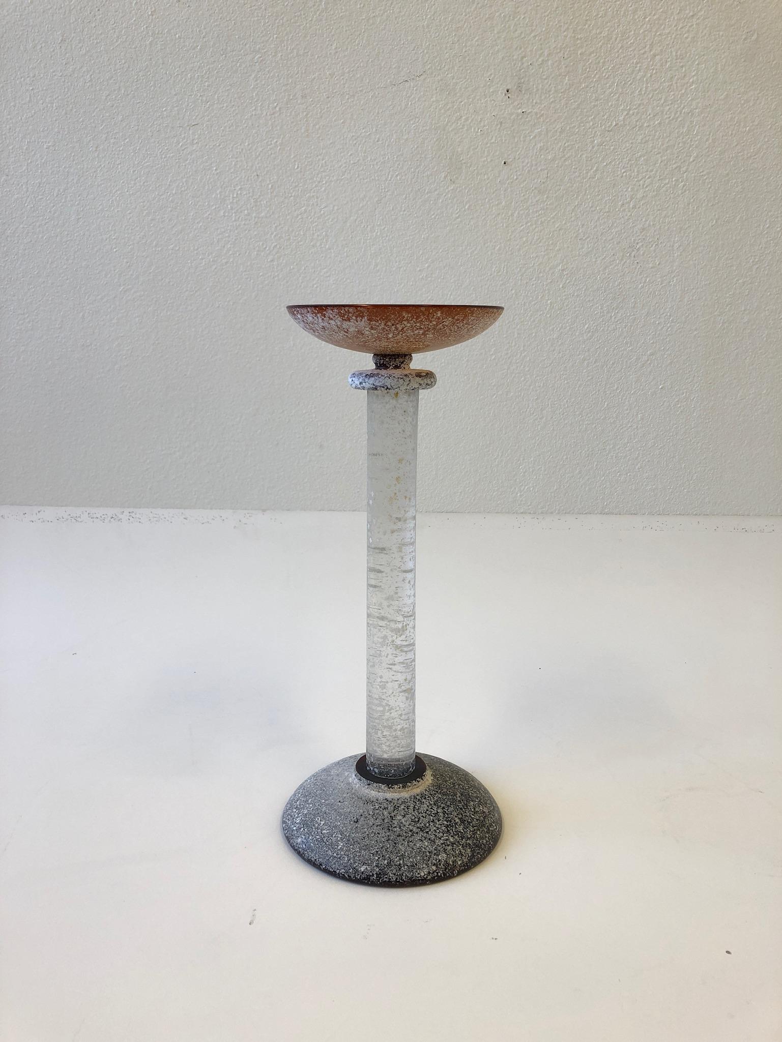 1980’s glamorous Italian Scavo Murano glass candlestick designed by Karl Springer for Seguso. 
Constructed of rough texture amber and clear Murano glass. 
Measurements: 18.25” high and 8” diameter.