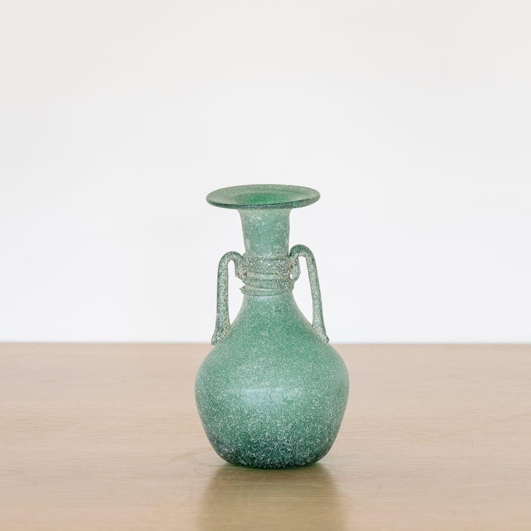 Vintage Italian Scavo style amphora vase made of frosted green glass from Murano, Italy. Great ribbed glass detailing on neck. Small break on handle has been newly repaired. See photos.