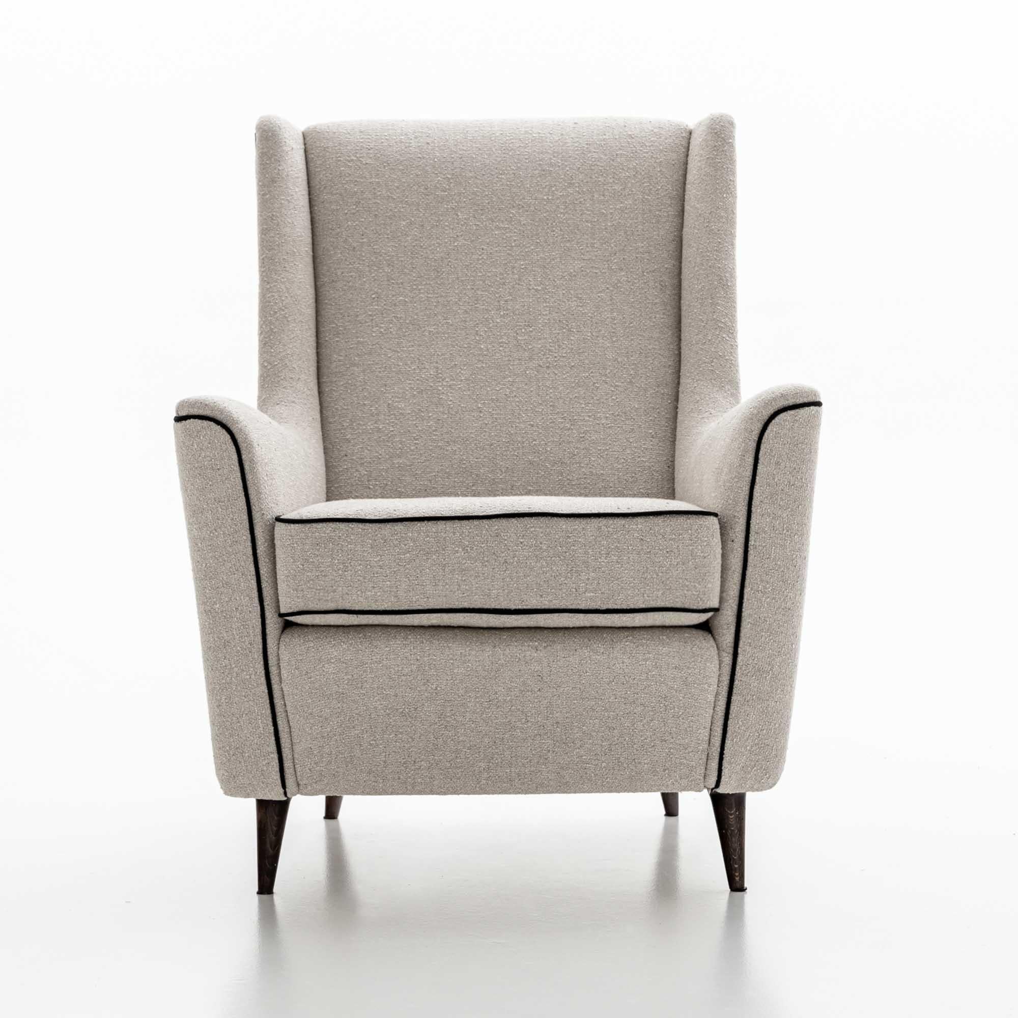 Italian Design armchair with tapered black feet and high backrest with upholstered seat on all sides. The armchair has been reupholstered in a light gray fabric with black piping. 