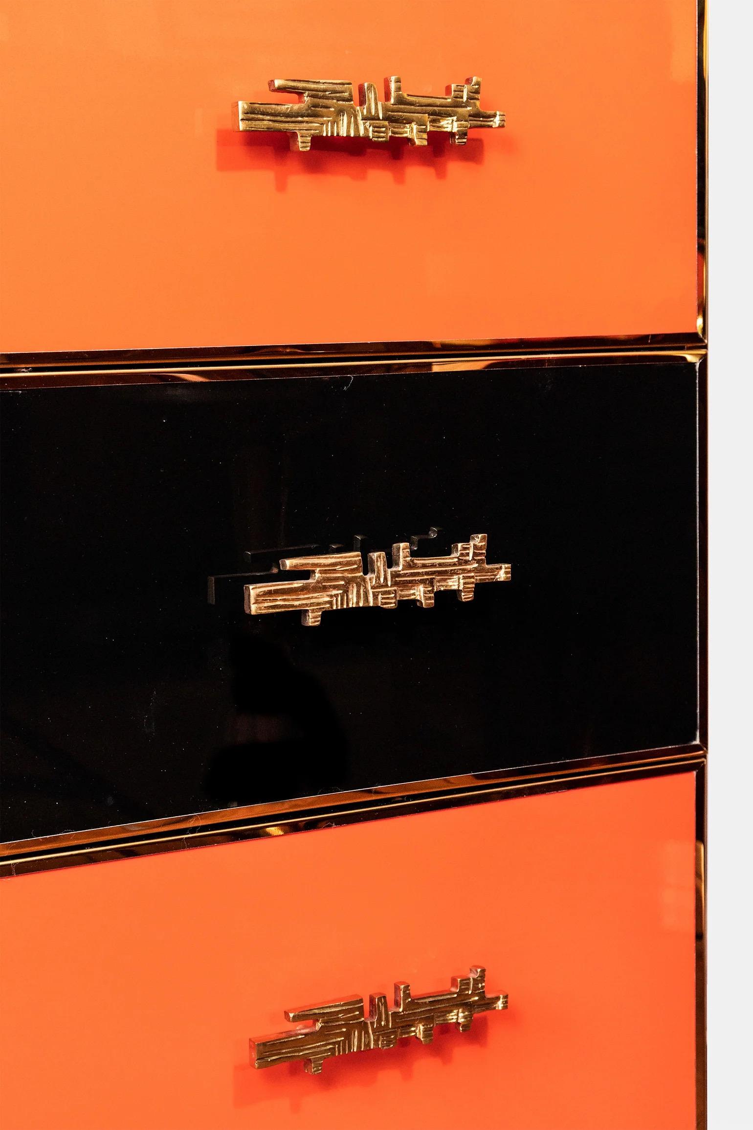 École italienne, vers les années 1990 - 2000
Une commode postmoderne italienne qui se distingue par son audacieux design en damier noir et orange. La pièce présente une structure en bois massif méticuleusement finie dans une laque brillante, créant