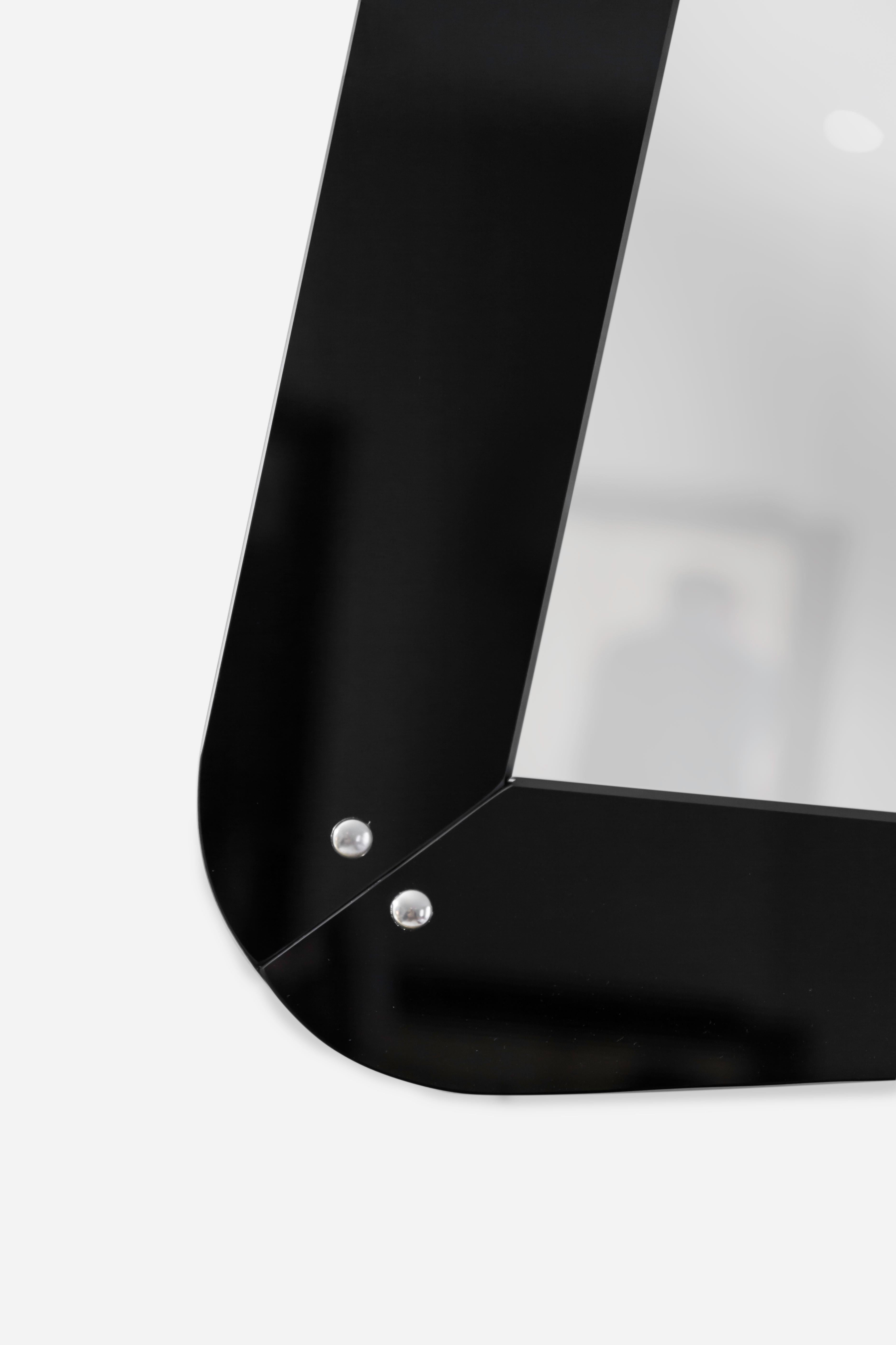 An Italian School Opaline glass wall mirror, made circa 1960
Framed mirror in black opaline and mirror glass.
Produced in Italy, this elegant mid-century mirror exemplifies the sophistication and craftsmanship of Italian design. The subtly curved