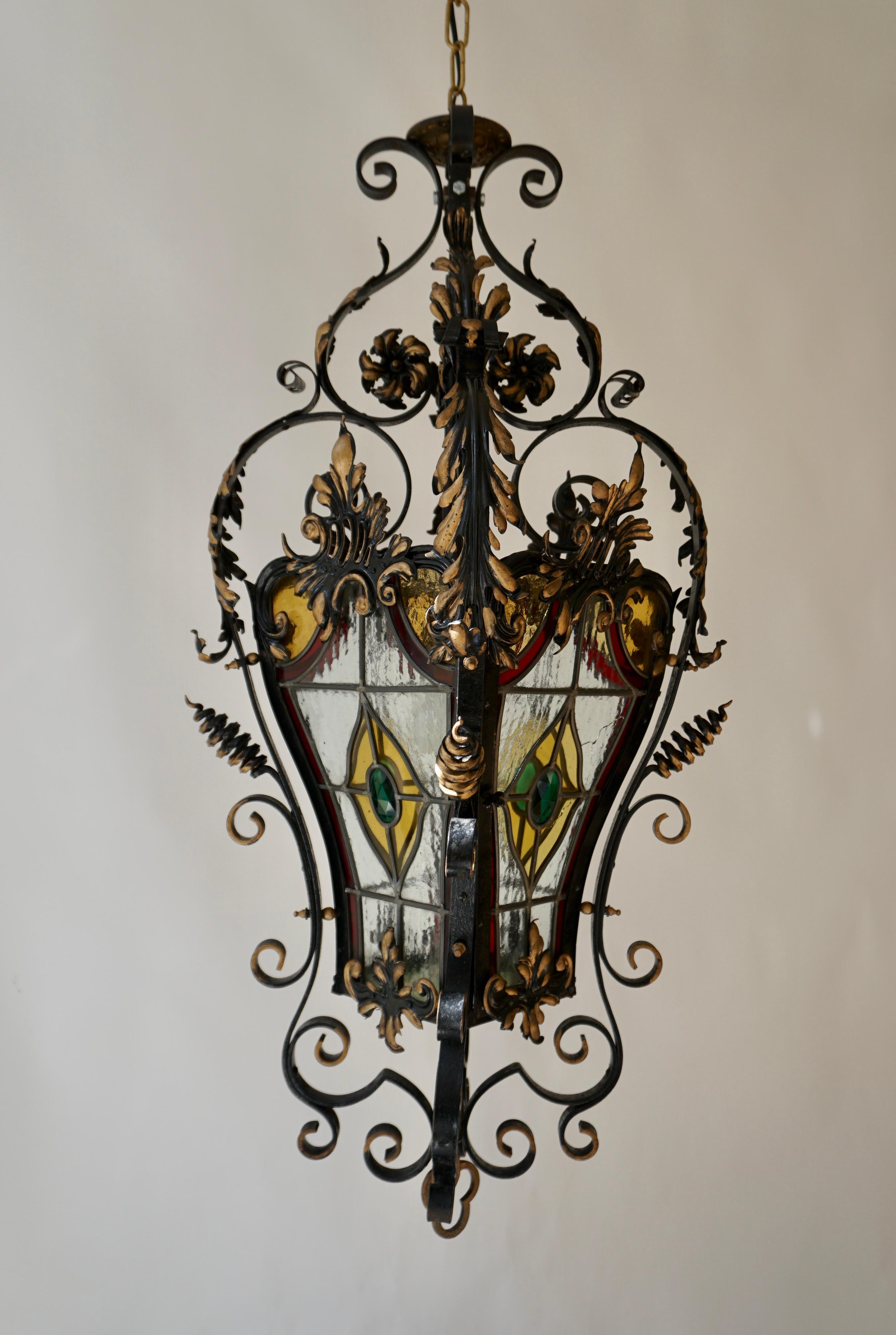 Elegant Italian scrolled foliage wrought iron and stained glass hanging hall lantern with one light interior. Originally candle powered and has been electrified.
Antique lantern with colored stained glass - leaded glass .A wrought iron French candle