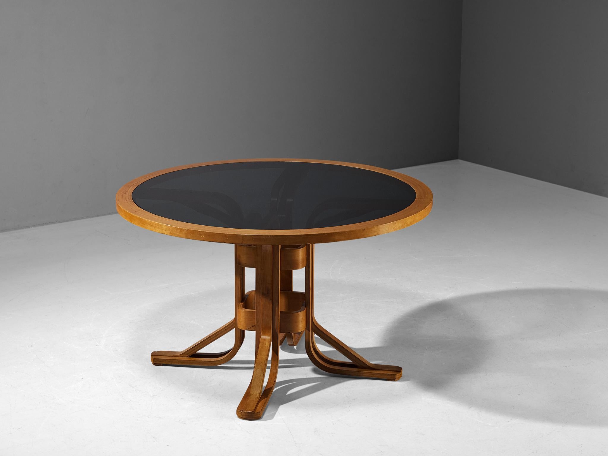 Dining table, maple plywood, smoked glass, Italy, 1970s

This postmodern dining table is well-constructed in a precise manner implementing geometric shapes that contribute to its architectural appearance. In the highly sculptural base, you can see