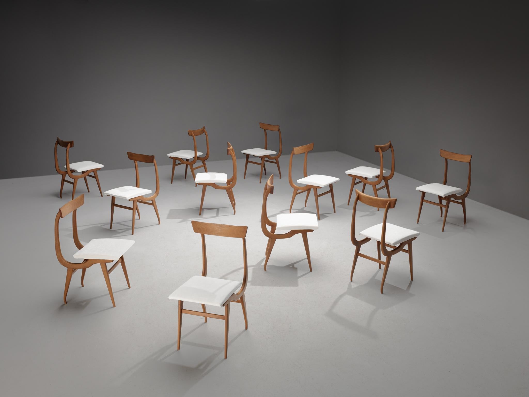Ensemble de douze chaises de salle à manger, noyer, tissu : Dedar Belsuede col.8 pierre d'argent, Italie, années 1960

Ces chaises italiennes ont une apparence dynamique qui se manifeste, par exemple, dans le cadre organique de forme incurvée. Un