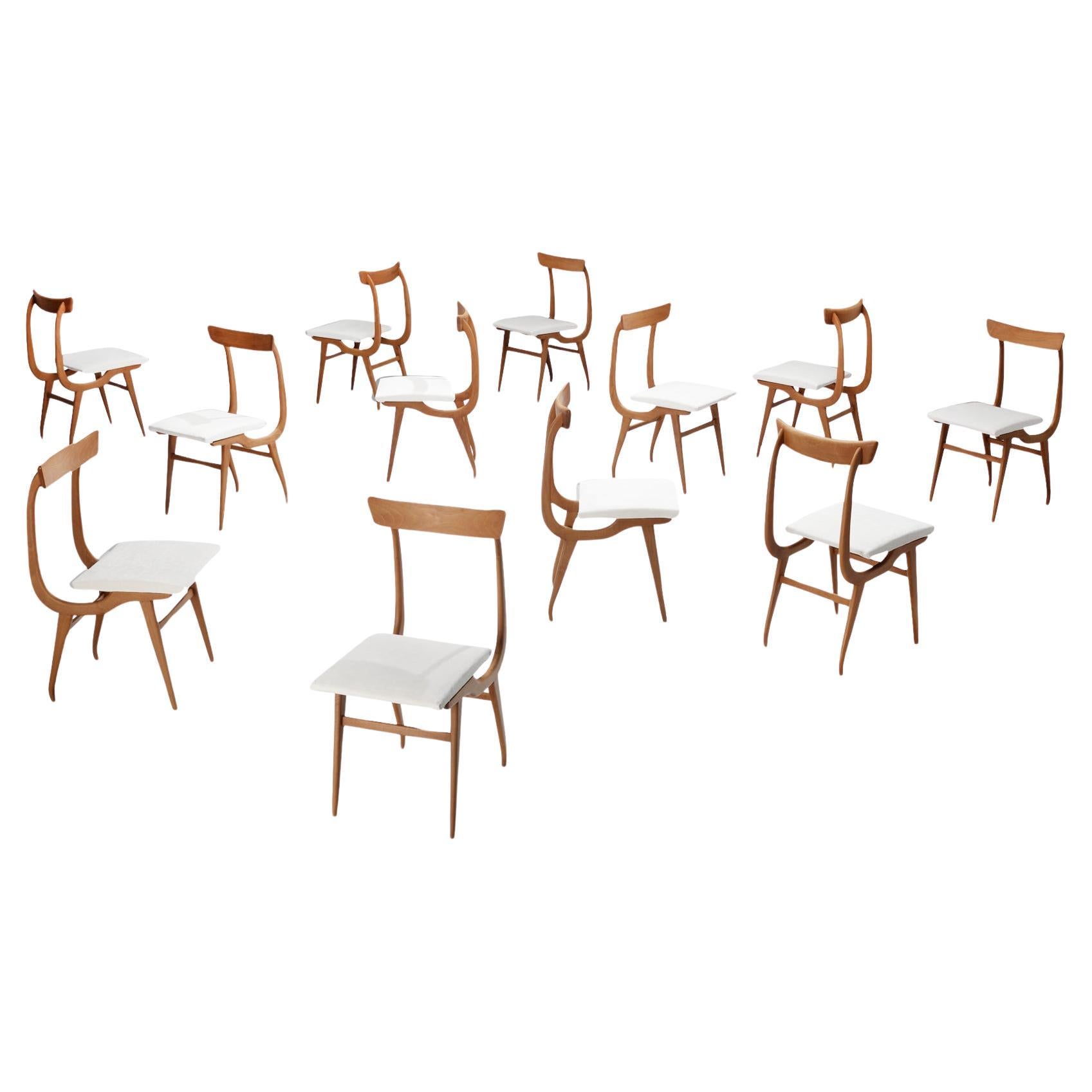 Ensemble sculptural italien de douze chaises de salle à manger en noyer  en vente