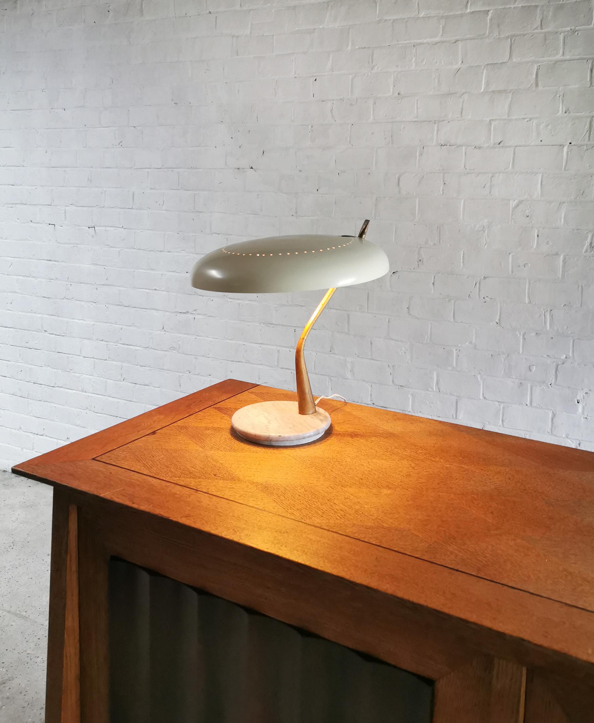Beautiful Italian desk or table Lamp by Lumen Milano, 1950's. This lamp features a round adjustable perforated lampshade that is connected on a sculptural bent brass stem. The base is made out of round shaped carrara marble.

Fully functional, ready