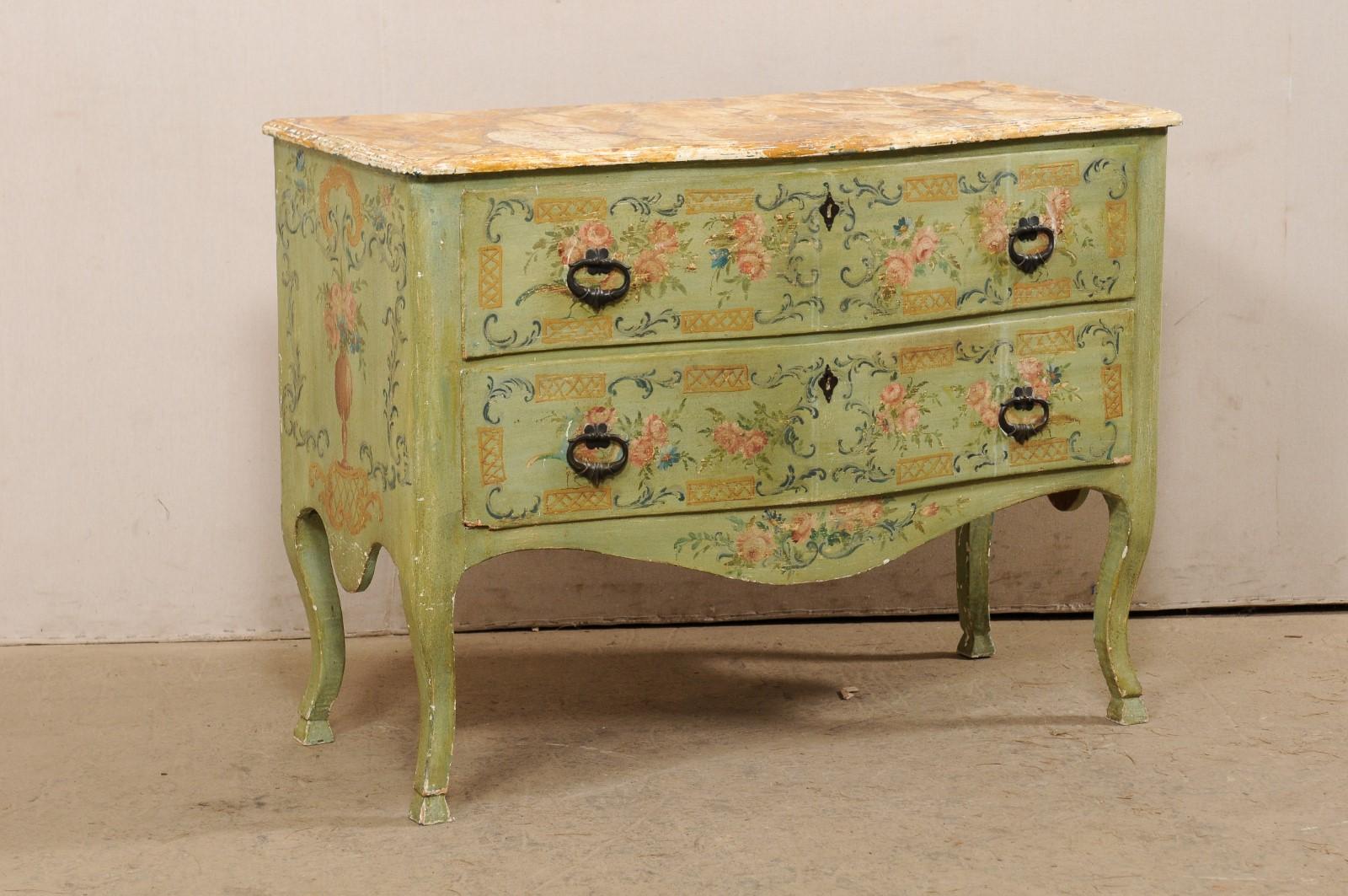 An Italian hand-painted raised chest, with subtle serpentine body, from the early 19th century. This antique chest from Italy is ornately decorated in a hand-painted floral, lattice, and urn motif about the front and sides. The commode has a nice