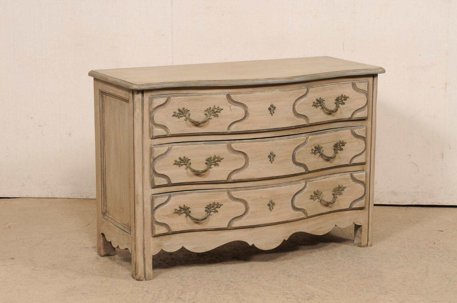An Italian painted wood chest of drawers from the mid 20th century. This vintage bureau from Italy has a softly curved serpentine front, with case housing three full-sized drawers, a beautifully scalloped skirt along three sides, and presented on