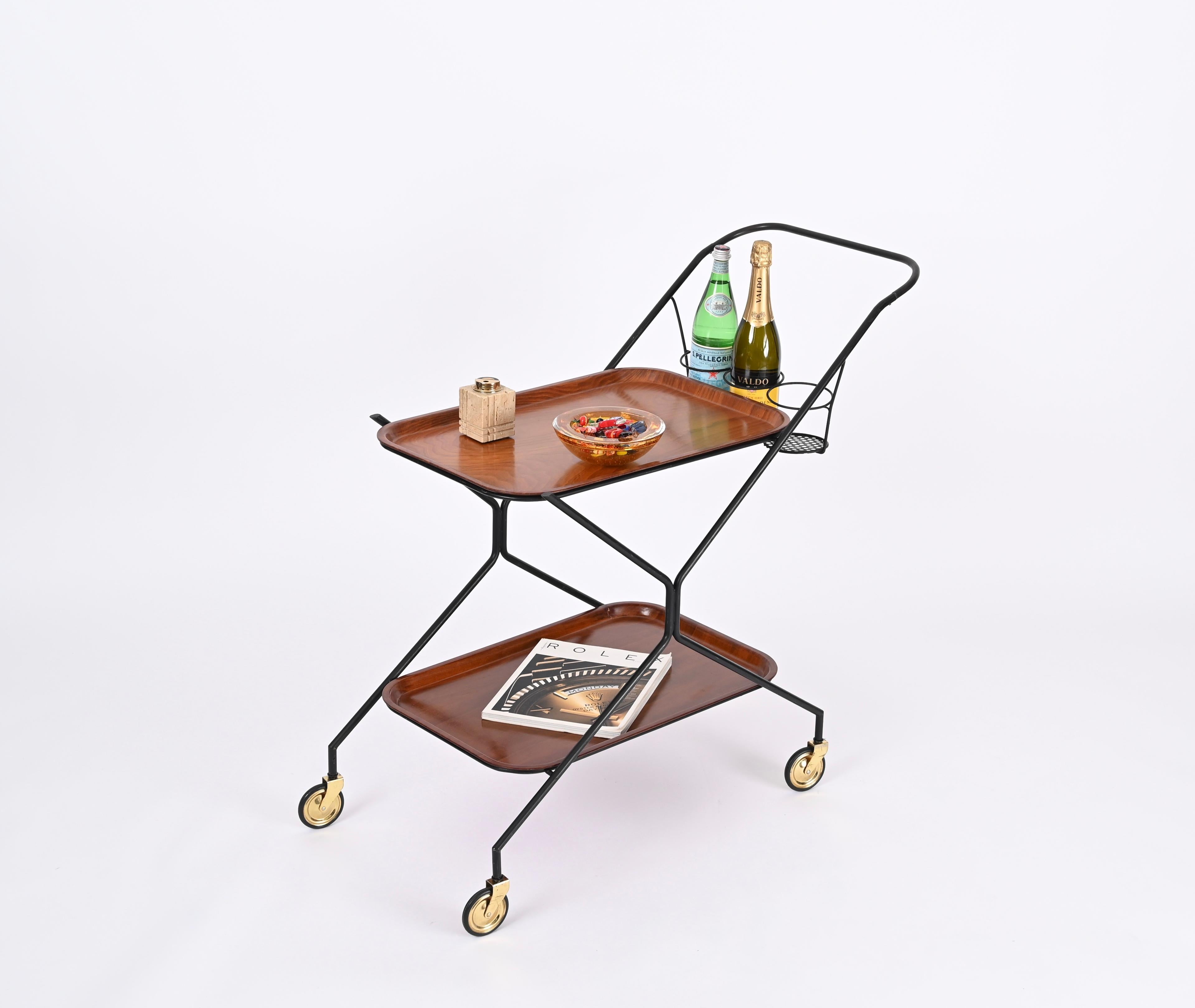 Lovely Mid-Century serving bar cart with oak wood removable trays. This unique piece was produced in Italy during the 1960s.

This serving table has a beautiful structure in bent tubular metal which is black enamled. The trays are made in a stunning