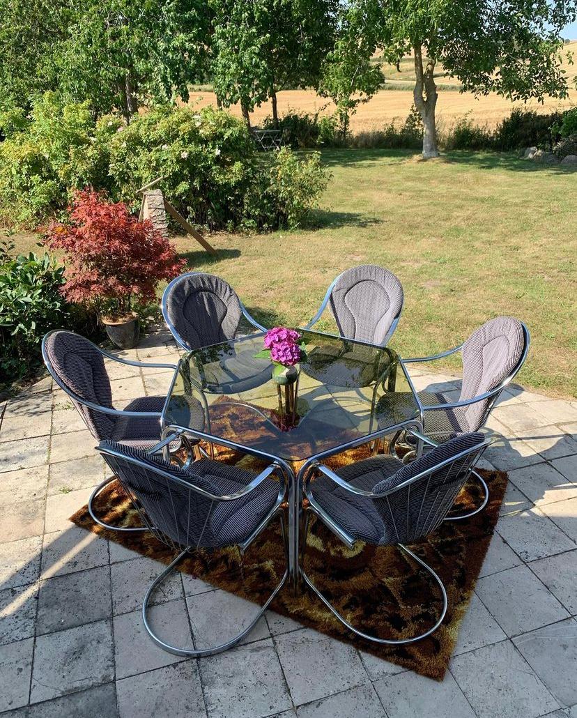 Mid-Century Modern spage age set, designed by Italian Gastone Rinaldi. 6 armchairs and a dining table with smoked glass on top. Produced in the 70s. The set is made om chome-plated metal and is in a good original condition. Cushions are original and