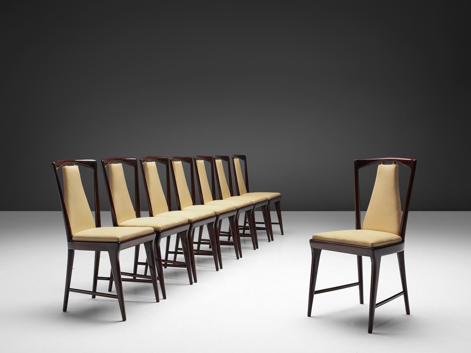 Set of eight dining chairs with beige faux leather and mahogany frame, Italy, 1950s. 

These classic chairs have square seats and delicately shaped backs. The beige seat and back element is connected to the stained mahogany frame via brass joints