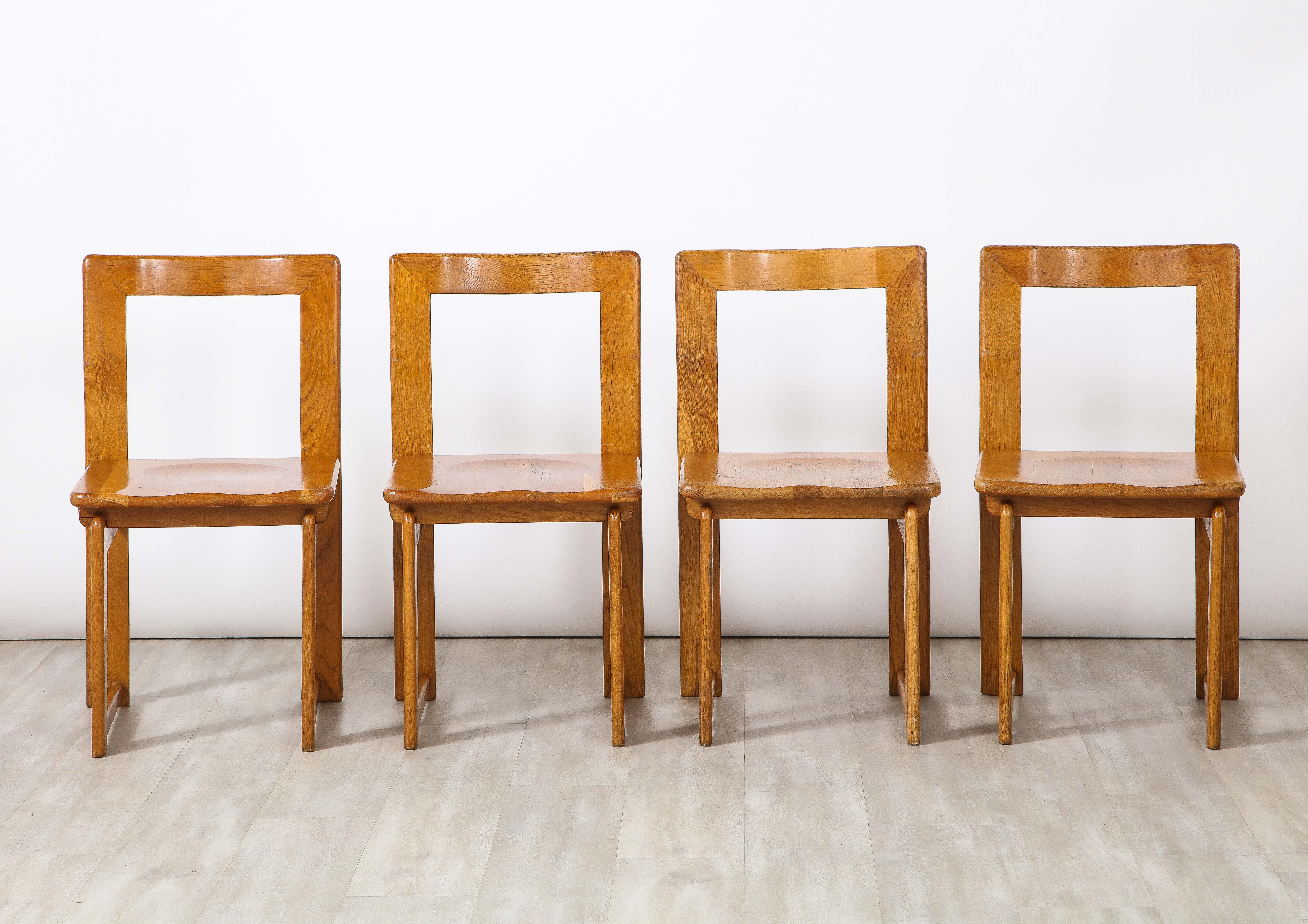 Ein charmantes Set aus vier rustikalen italienischen Eichenstühlen mit offener Rückenlehne. Die obere Rückenlehne ist elegant geschwungen und hebt die Einbuchtung der Sitzfläche hervor, die auf geraden Beinen mit ineinander greifenden Gelenken ruht.