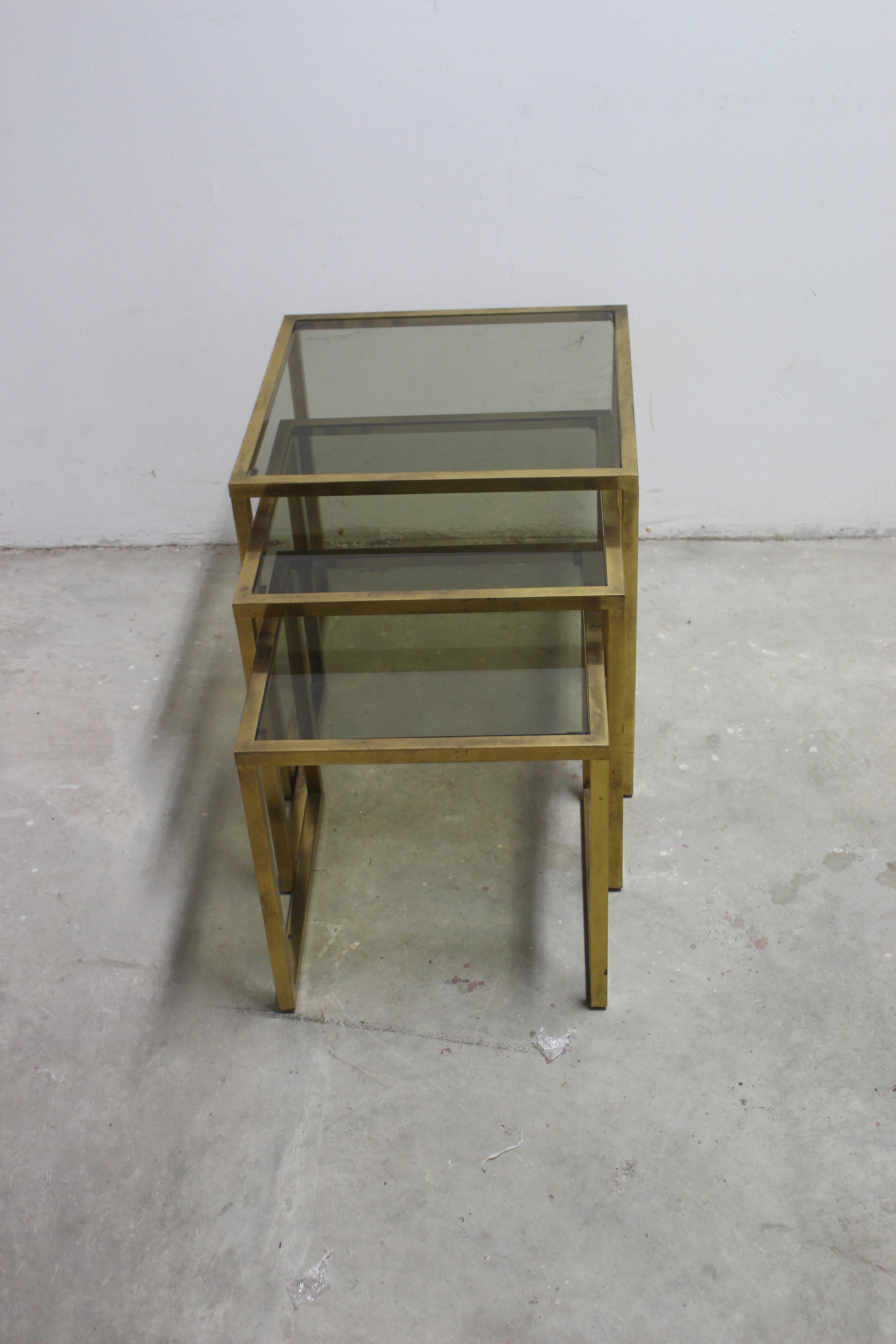 Mid century set of three nesting tables. Antique brass base with the fume glass top. Brass is not polish but shows original condition. We can polished on request.
Medium table dimension is: H: 18, W: 18, D: 18
Small H: 16, W: 16, H: 16.