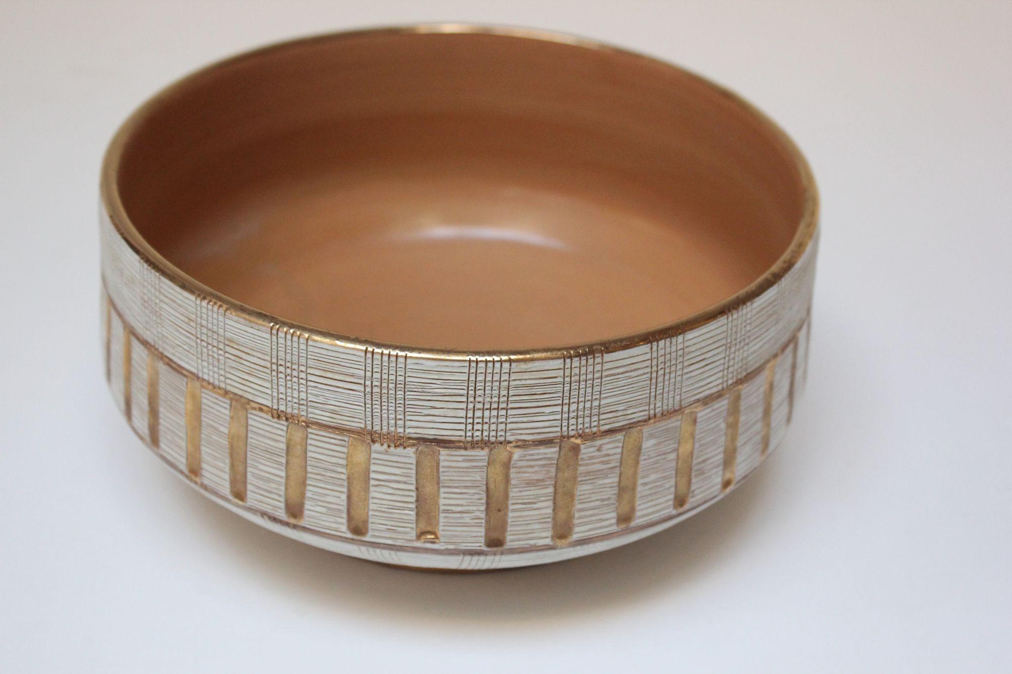 Glamorous vintage ceramic bowl with incised design and hand-painted gold accents designed by Aldo Londi for Bitossi (ca. 1950s, ltaly).
The etched sgraffito linear pattern reveals the beige base under the matte white glaze.
Excellent, vintage