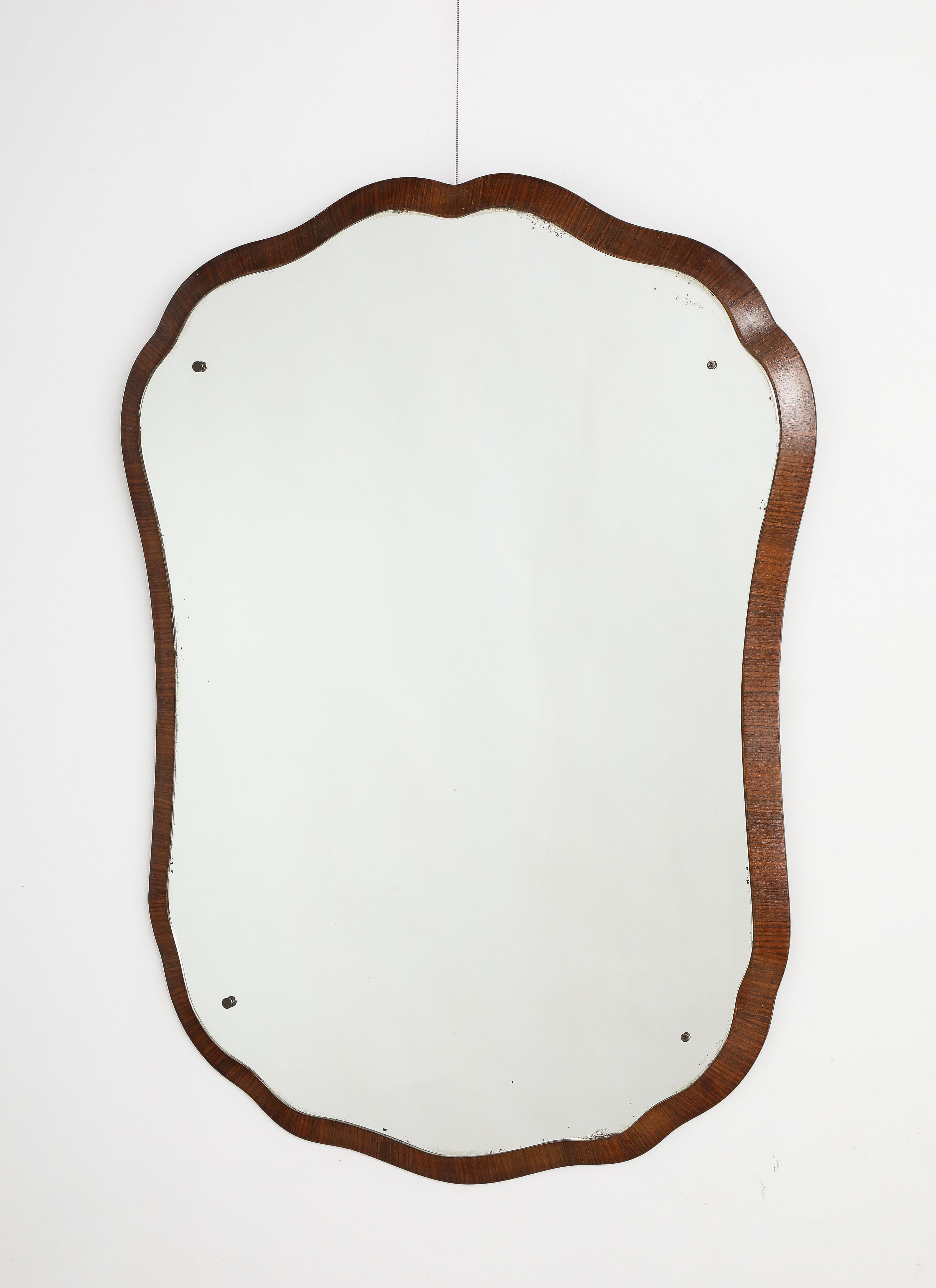 Miroir en bois de palissandre italien de grande taille, unique et élégant, en forme de cartouche.  Le cadre moulé en bois de palissandre supporte la plaque de verre originale qui suit la forme du cadre extérieur en bois.  Une pièce étonnante dont la