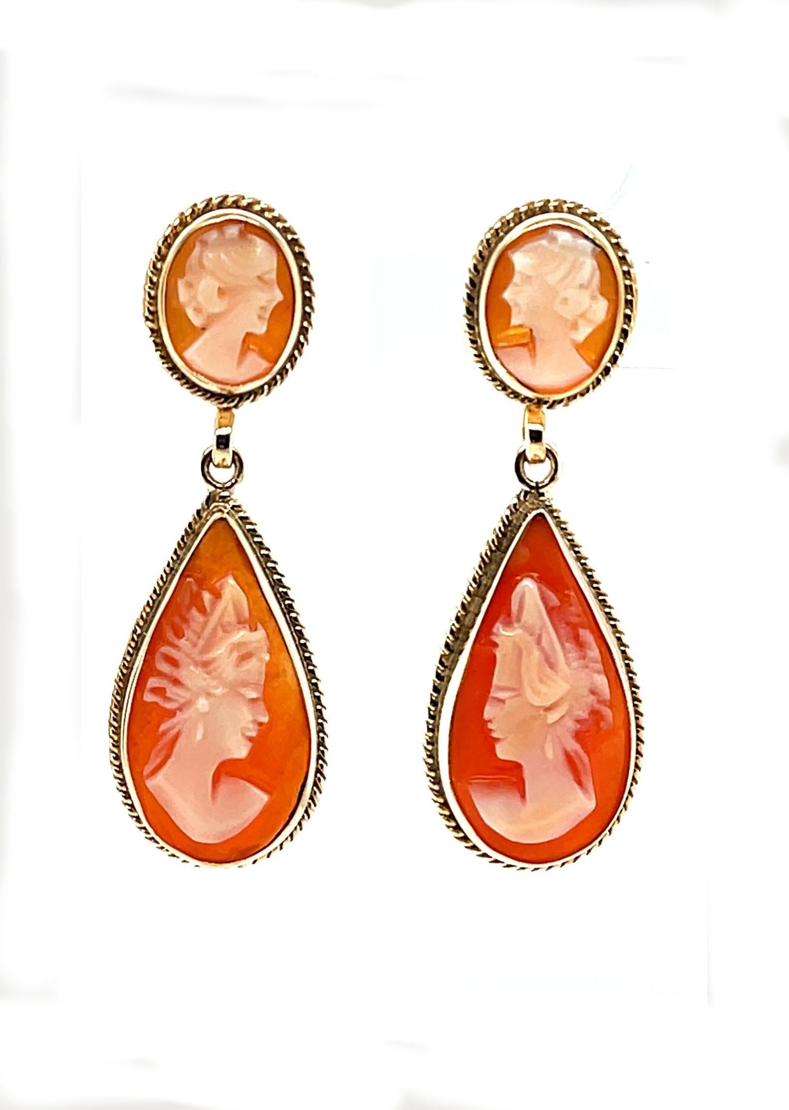 These beautiful drop earrings feature intricately carved Italian shell cameos. Each cameo is carved with a delicate and captivating profile showing elegance and individual personality. The cameos are bezel set in precious 14k yellow gold and
