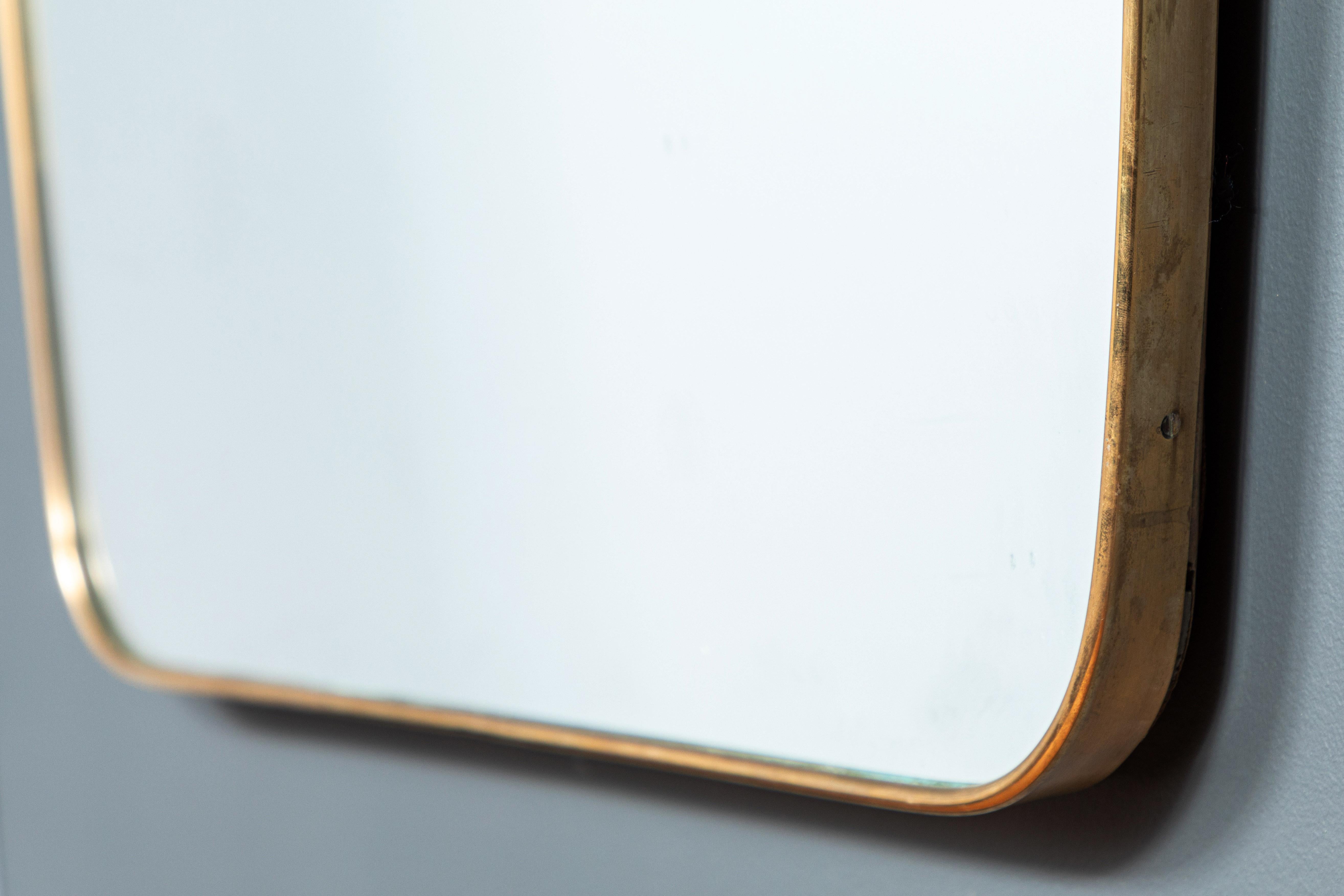 Italian shield mirror with brass frame, unique Italian midcentury shape offers a nod to Italian design.