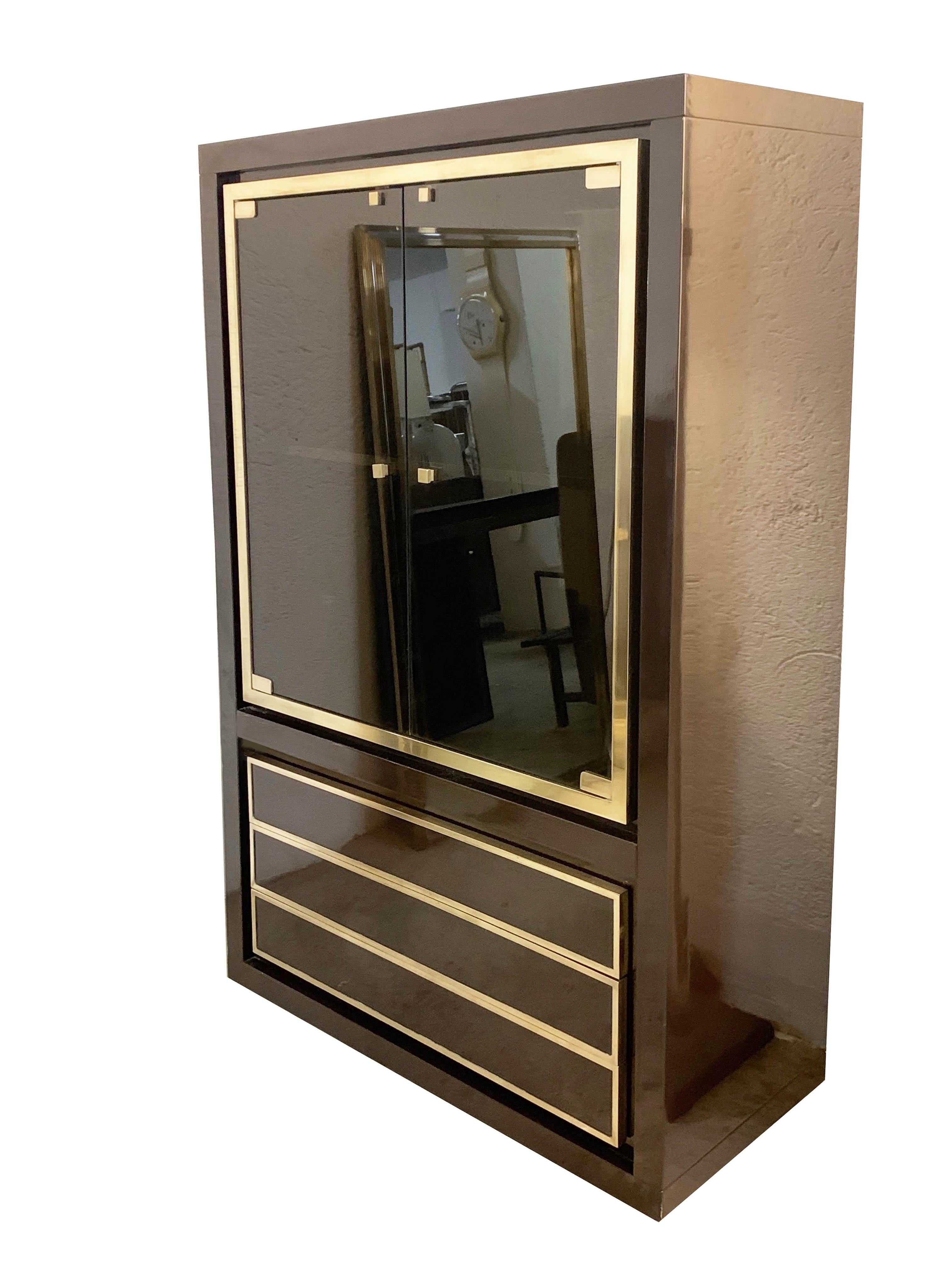 Marvellous and elegant Italian showcase cabinet from 1970.

The excellent quality of dark brown lacquer with glass panels embellished and solid brass is mixed with a lacquered shelf inside and three underlying drawers framed in solid brass. It is