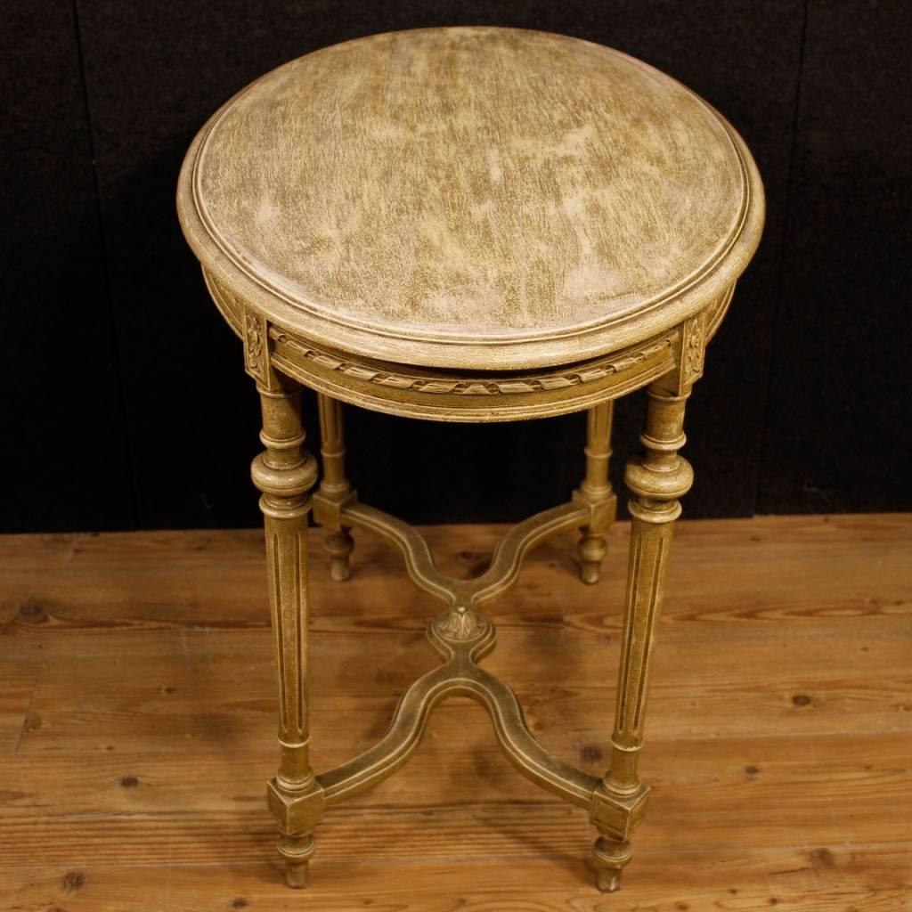 Italian side table of the 20th century. Louis XVI style lacquered wooden furniture. Coffee table of beautiful decoration and pleasant furnishings. Table with oval top of good measure and service. It presents some small drops of color, overall in