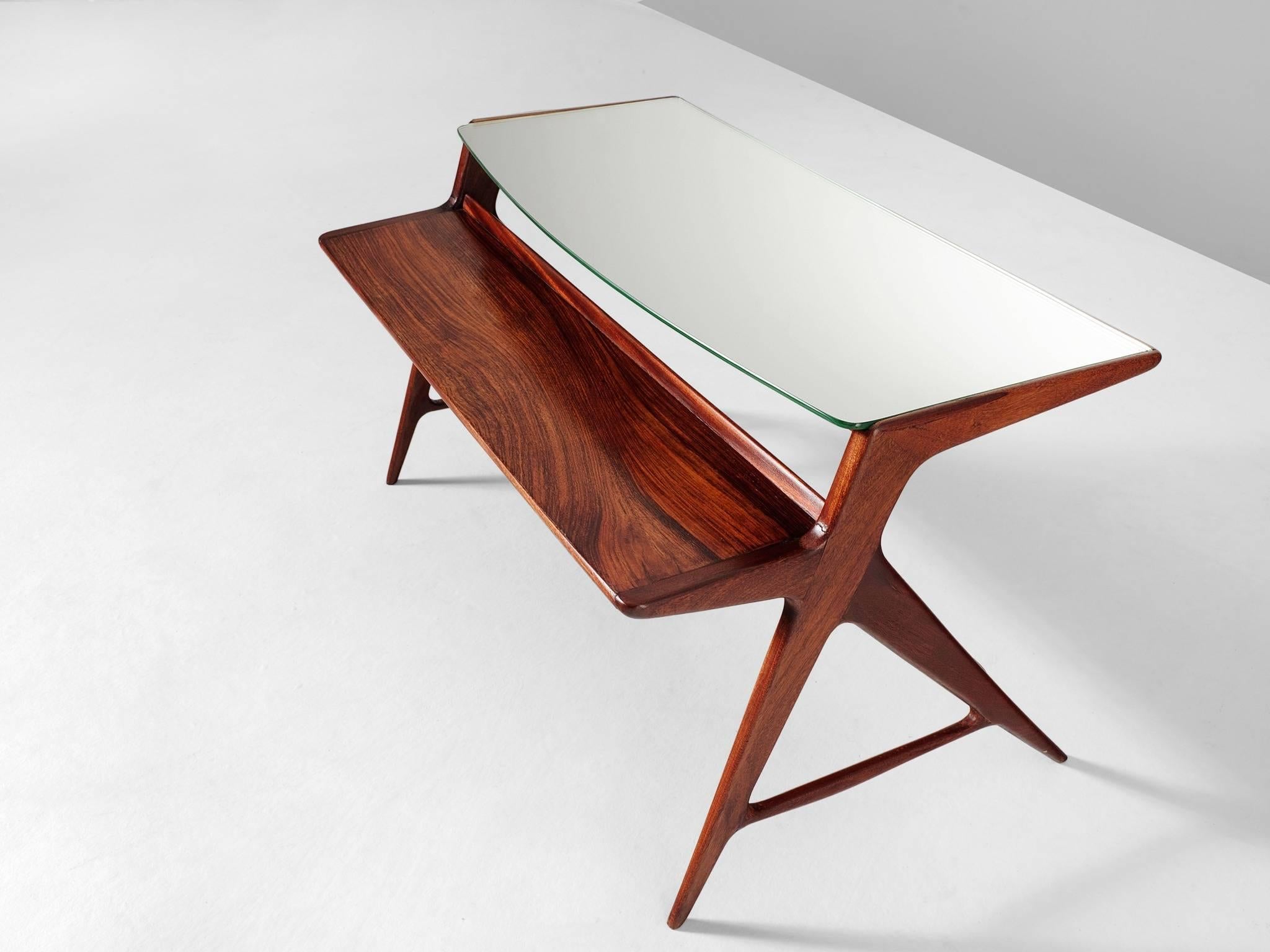 Cocktail table, in rosewood and glass, Italian, 1950s. 

Elegant side-table with mirrored top. The rosewood frame shows beautiful lines, especially seen in the tapered and crossed legs. The top consists of two rectangular plates, both on a different