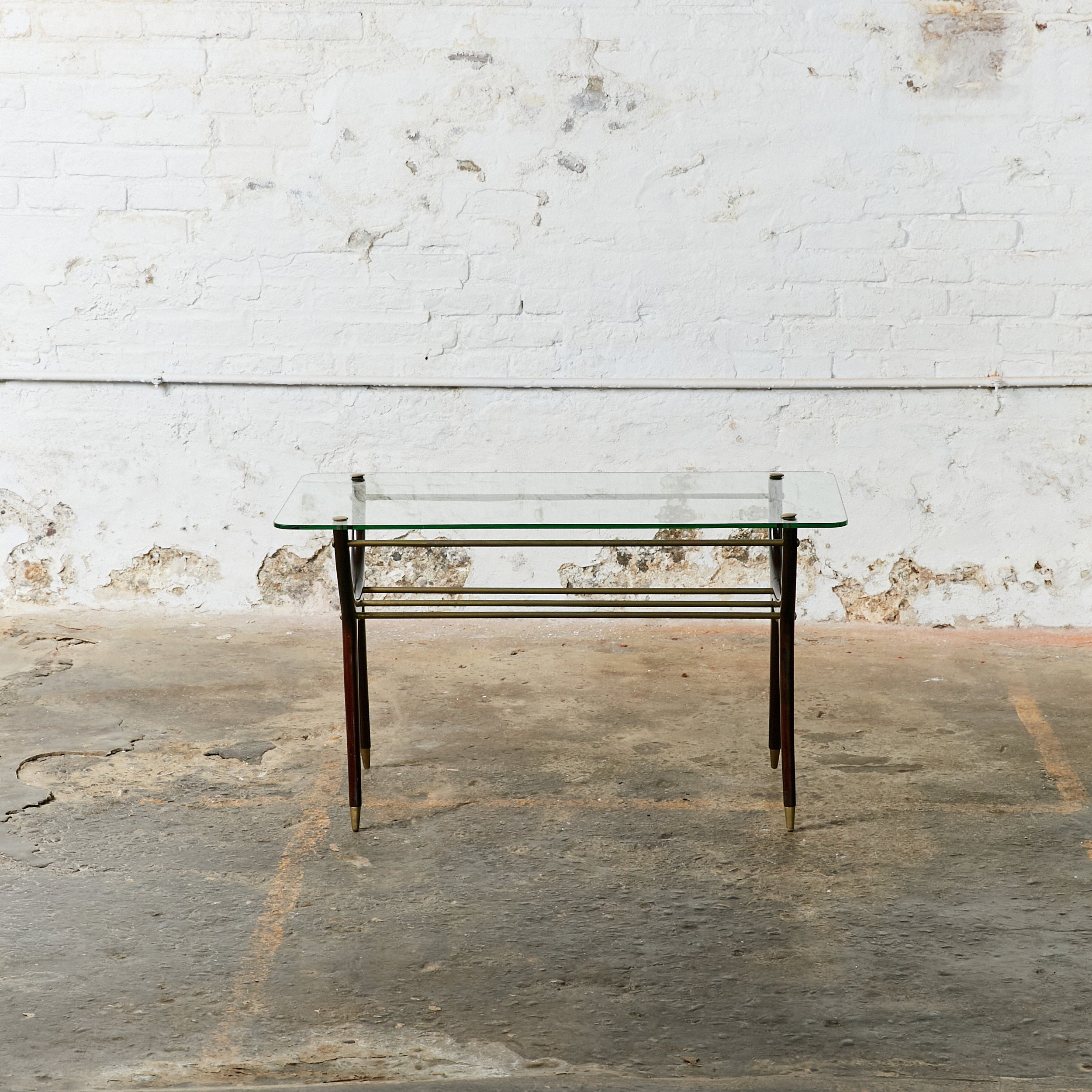 Italian side table in the style of Ico Parisi. Made of solid dark stained wood, brass details and clear glass top.
