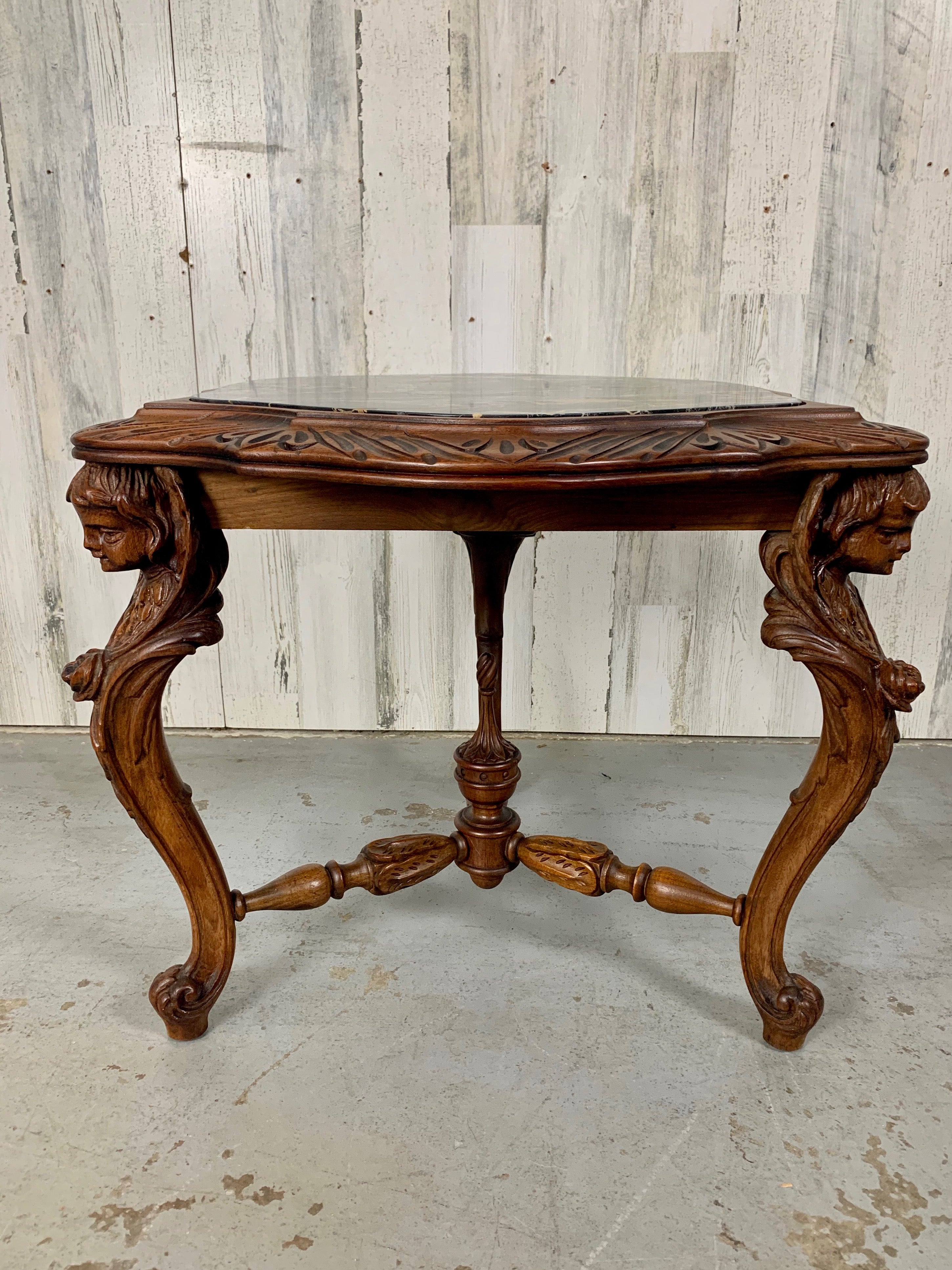 Dreibeiniges Design mit handgeschnitzten, geflügelten Cherub-Cabriole-Beinen.  Drei-Wege-Strecke an den Beinen und Fackel Stil Finial in der Mitte befestigt. Schwarze Marmorplatte mit hellbraunen, weißen und grauen Adern und geschnitzter