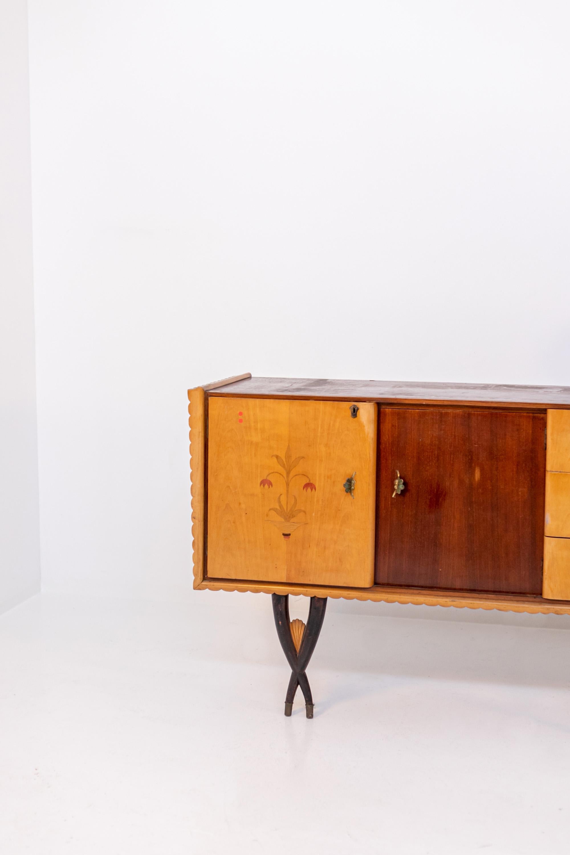 Large Italian sideboard attributed to 1950s designer Paolo buffa. The sideboard is made of various types of wood. The sideboard with four doors and three drawers in the center. The two side doors are in light wood and the central ones in darker