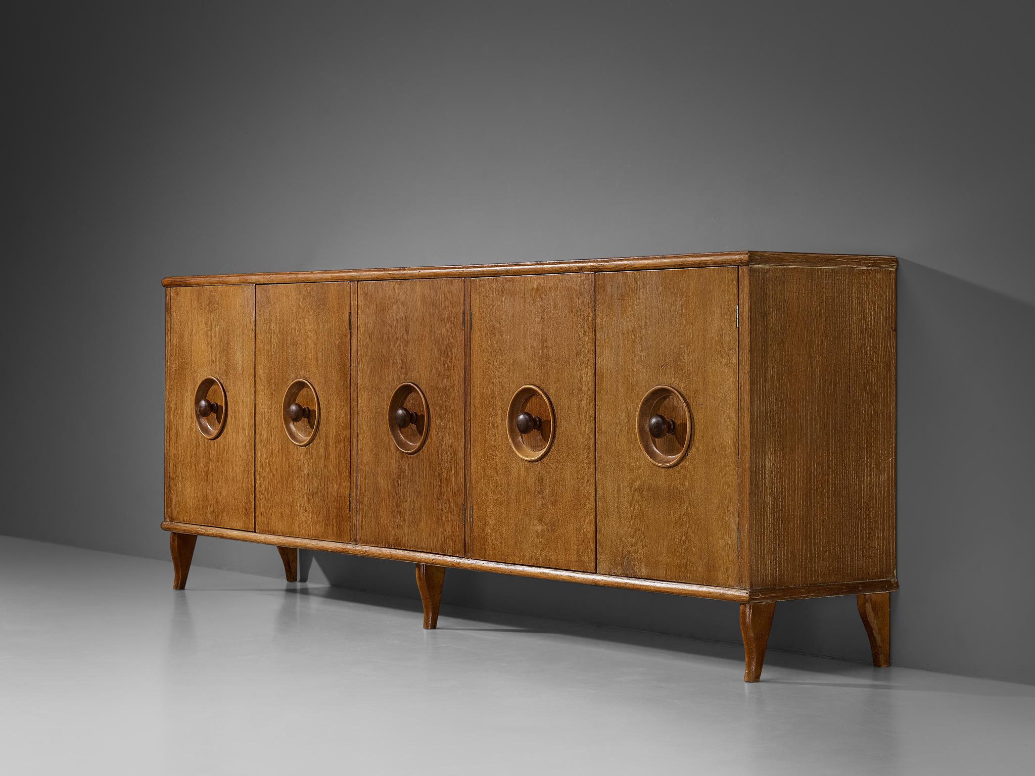 Sideboard, cerused chestnut, beech, mahogany, Italy, 1940s

A charming sideboard of Italian origin and dating back to the 1940s, encapsulates the Art Deco flair of that period. The corpus features five doors, each decorated with a round recessed
