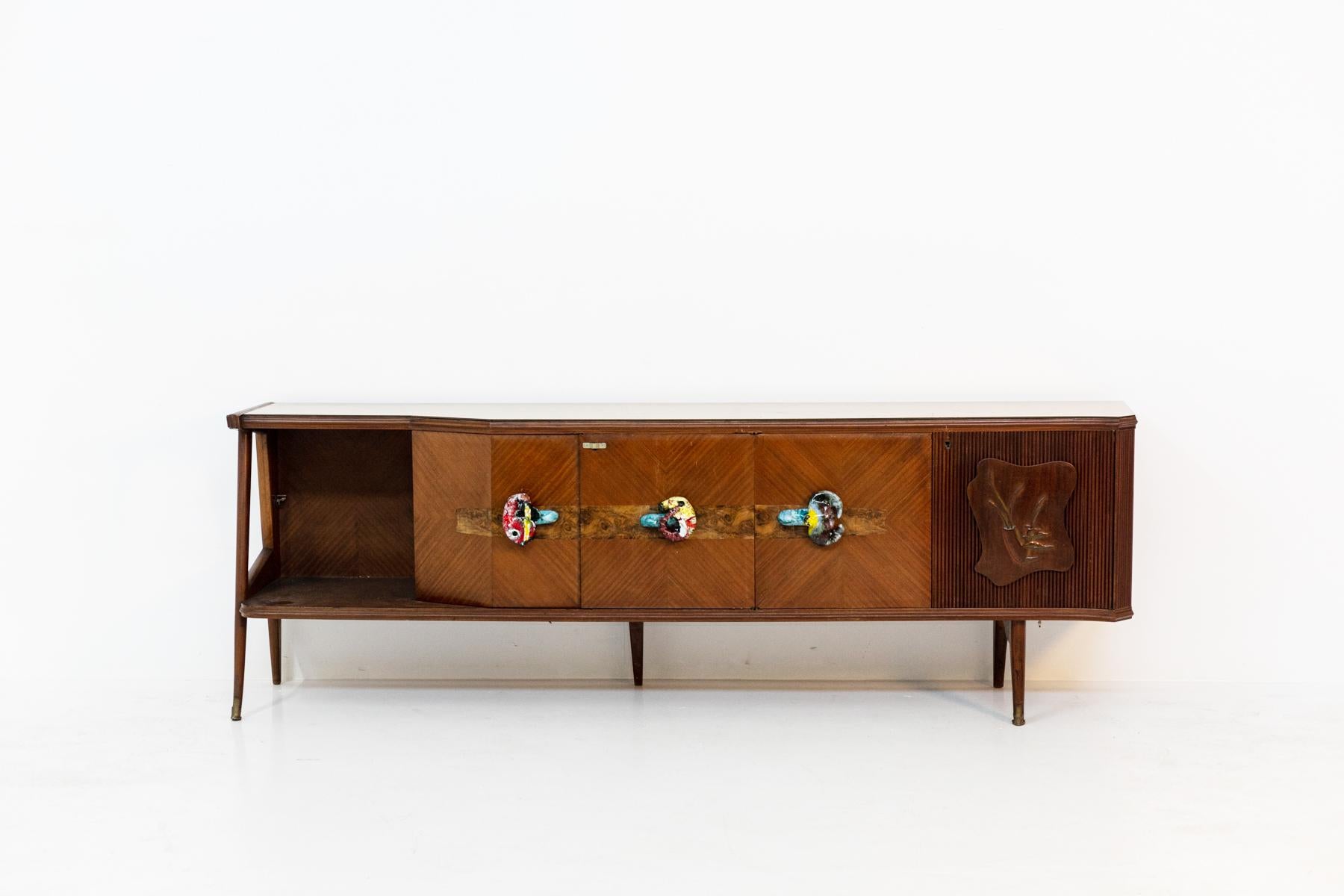 Large and beautiful Italian sideboard from the 50's. The sideboard has multiple functions. As a support surface we find a beautiful yellow glass original of the time. In the two sides are a 'cove where to store various objects, while in the left